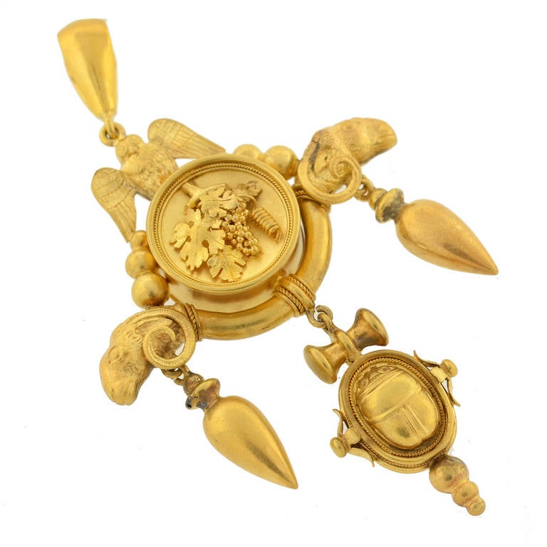 A truly exceptional gold pendant from the Victorian (ca1880) era! Made of vibrant 15kt yellow gold, the pendant is large in size and has an elaborate design. The center is round and decorated with a raised cluster of leaves and grapes. An owl sits