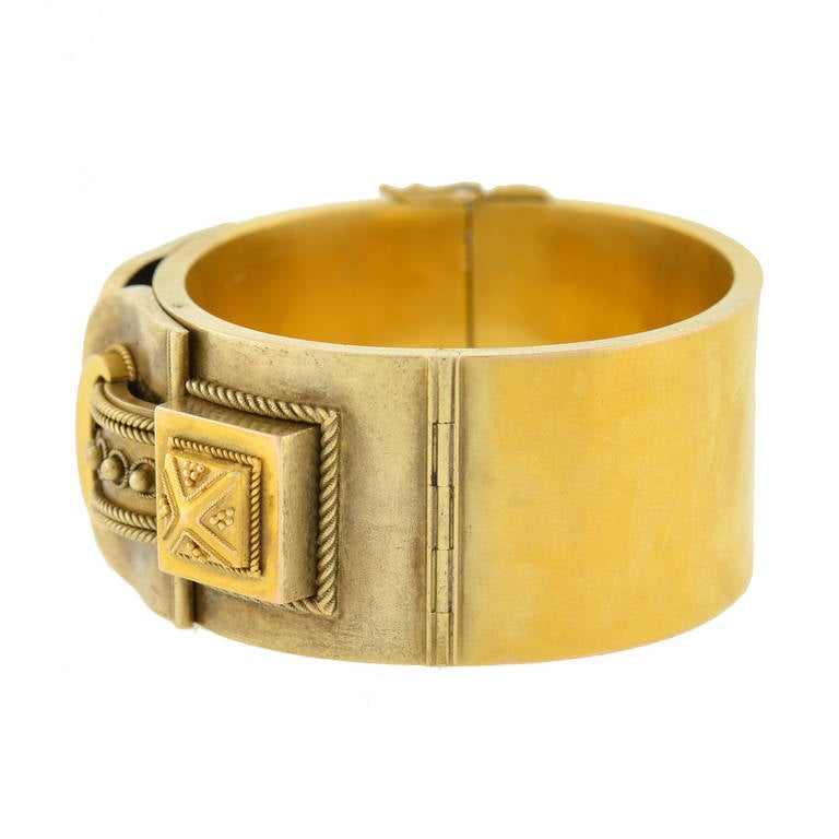 An incredible gold bracelet from the Victorian (circa 1880) era! This wide, three-dimensional bangle is made of vivid 15kt yellow gold (indicating English origin) and has a fabulous double buckle design. The elaborate buckle design rests across the
