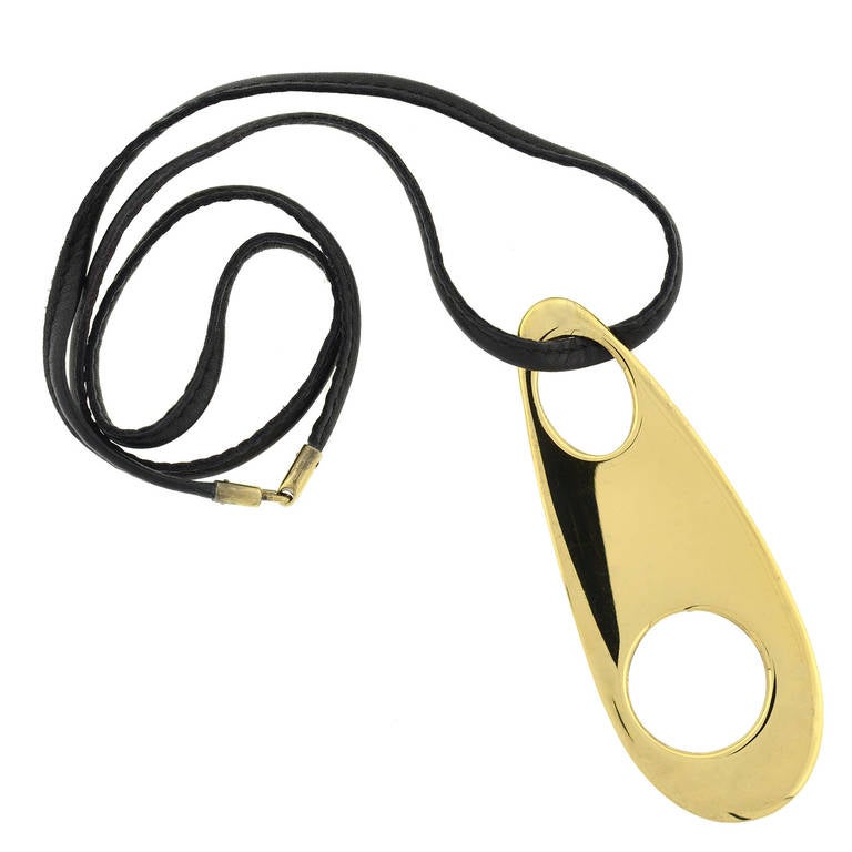 This striking Vintage pendant is a signed piece by Gucci! Made of gilded sterling, the heavy piece is very substantial in size and has a fashionable minimalist design. The pendant has an elongated flat oval shape with a large cutout circle and oval