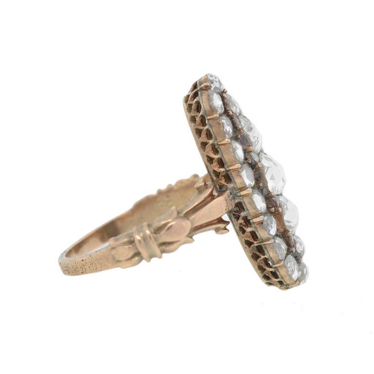 An outstanding diamond cluster ring from the Late Georgian (ca1830) era! This breathtaking piece is made of 12kt rose gold and features a gorgeous cluster of diamonds set within an elongated oval-shaped plaque. All of the diamonds are Holland Cuts,