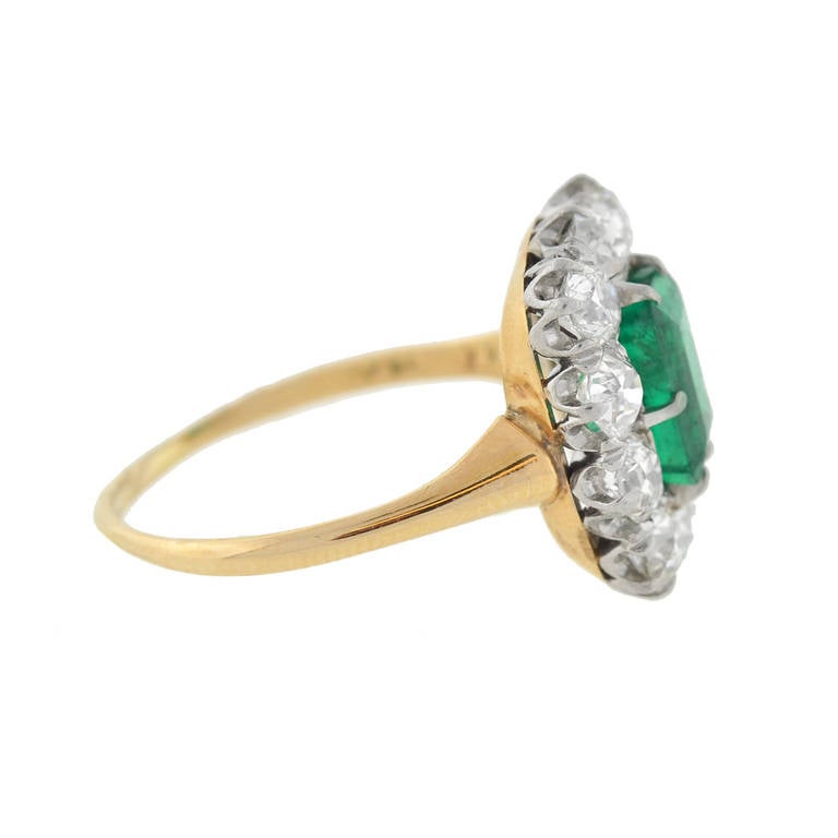 An absolutely breathtaking emerald and diamond ring from the late Victorian (ca1910) era! Made of platinum-topped 14kt yellow gold, this stunning ring features an exquisite 1.57ct Emerald Cut emerald in the center, surrounded by a border of 10 Old