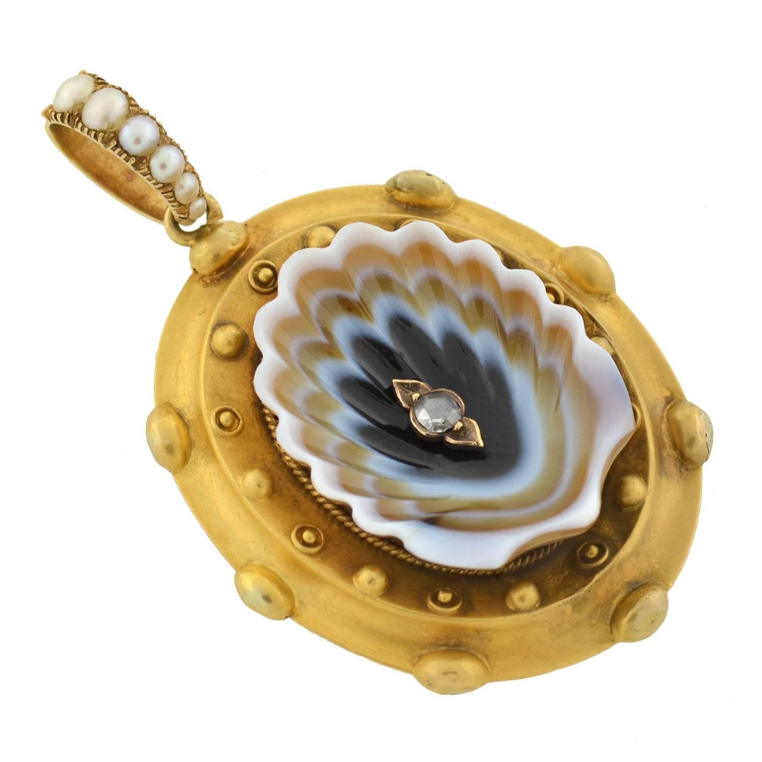 This extraordinary locket from the Victorian era (ca1880) is truly one-of-a-kind! Made of vibrant 18kt yellow gold, the piece has a very unusual 3-dimensional design. Resting in the center is a concave piece of hand-carved banded agate, which forms