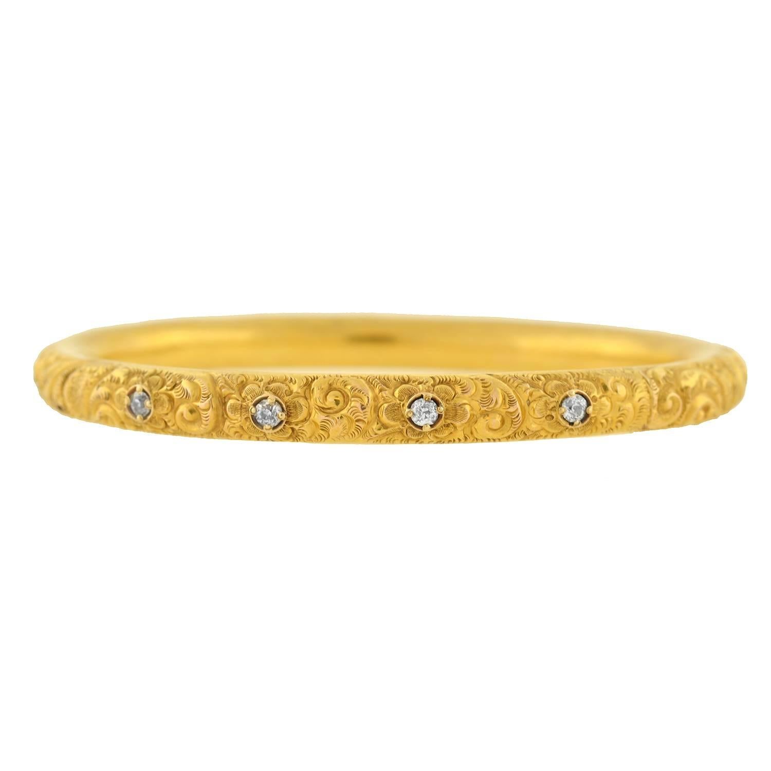 A stunning gold and diamond repousse bangle bracelet from the Victorian (ca1860) era! This lovely bracelet is made of vibrant 15kt yellow gold and is intricately detailed with a stunning floral and scrolled repousse motif along the surface of the