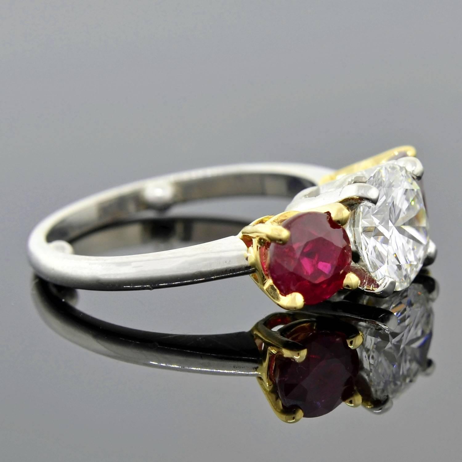 A truly spectacular diamond and ruby 3-stone ring! This breathtaking estate piece is crafted in platinum and holds a trio of gemstones at the center. The gorgeous trilogy design features a 1.58ct Modern Brilliant Cut diamond at the center framed by