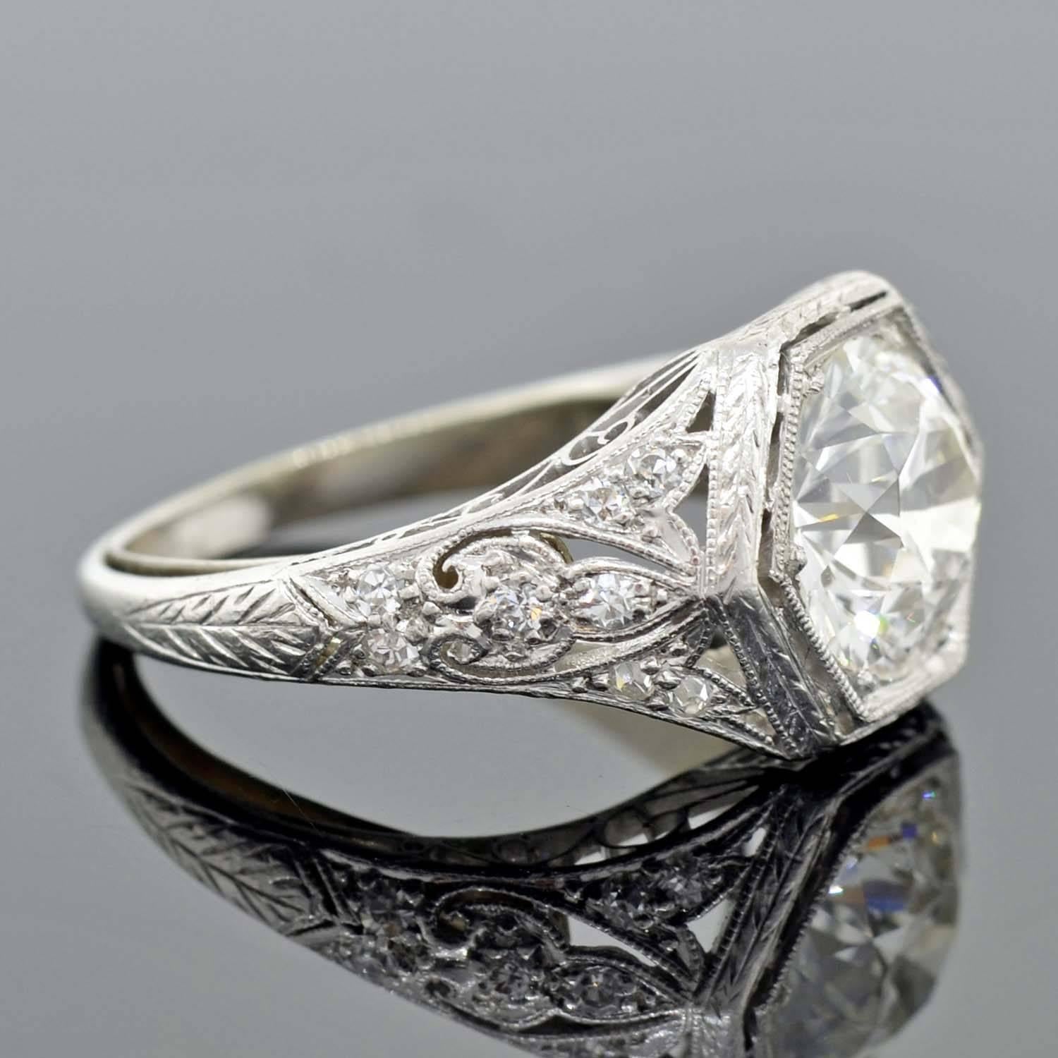 

An absolutely stunning diamond engagement ring from the Art Deco (ca1920) era! This beautiful piece is made of platinum and features a substantial old European Cut diamond resting at the center of an intricate filigree wirework mounting. The