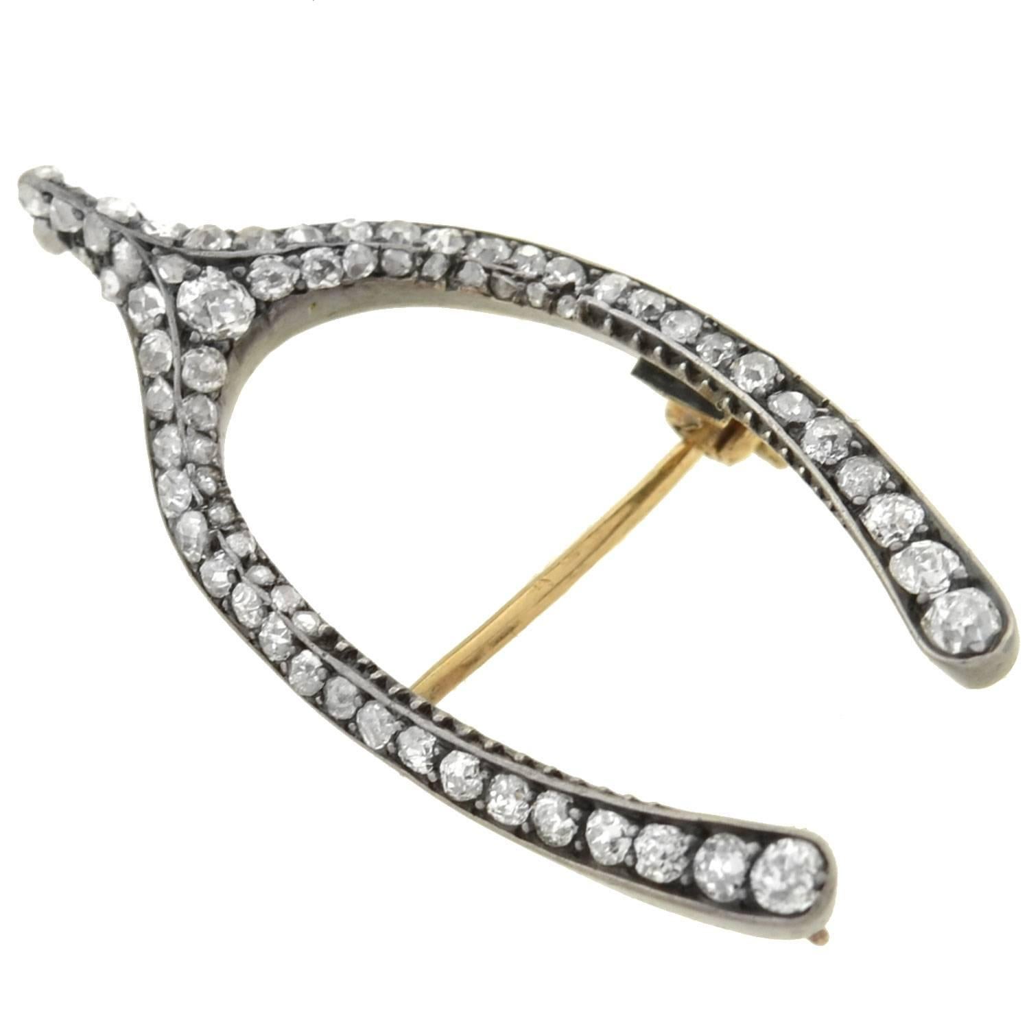A spectacular diamond wishbone pin from the Victorian (ca1880) era! Likely French in origin, this stunning pin is crafted in silver-topped 18kt yellow gold. The piece forms a 3-dimensional wishbone shape, which is adorned with a sparkling diamond
