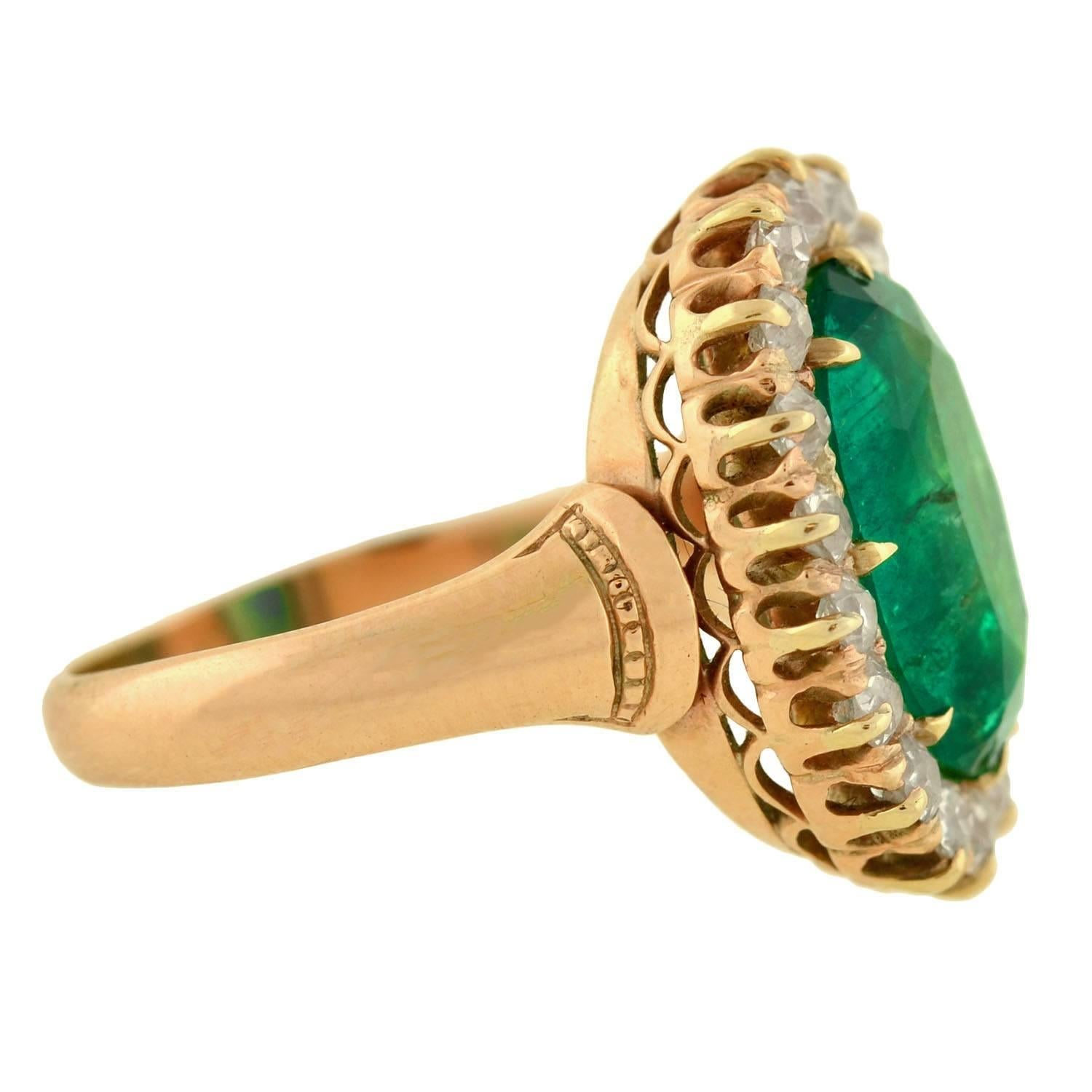 An absolutely exquisite natural emerald and diamond ring from the Victorian (ca1880) era! This wonderful piece has a a vibrant, faceted, emerald stone at its center which is surrounded by 18 sparkling, old European Cut diamonds. The diamonds are