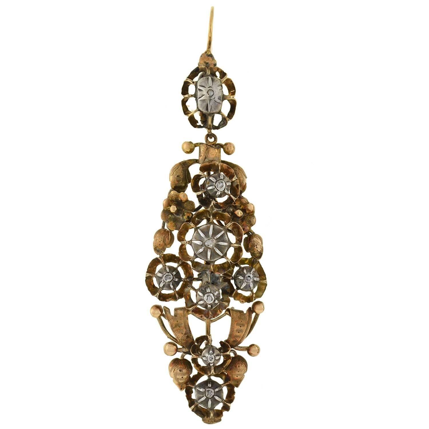 An incredible pair of earrings from the Victorian (ca1860) era! These impressive earrings are quite large in size and are handmade of sterling topped 14kt gold. The design is very ornate with flower like clusters, leaves, and ribbons that create a