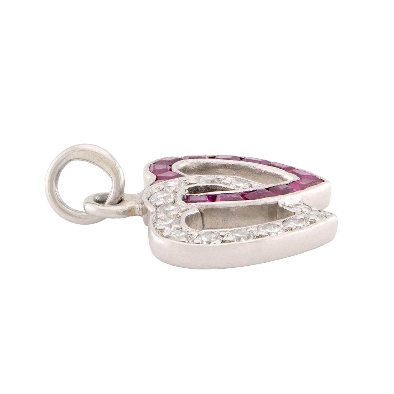 Un pendentif/bracelet en diamant et rubis absolument exquis de l'époque Rétro (ca1940s) ! Cette pièce est réalisée en platine et représente deux cœurs imbriqués l'un dans l'autre. L'un des cœurs est incrusté de diamants de taille européenne