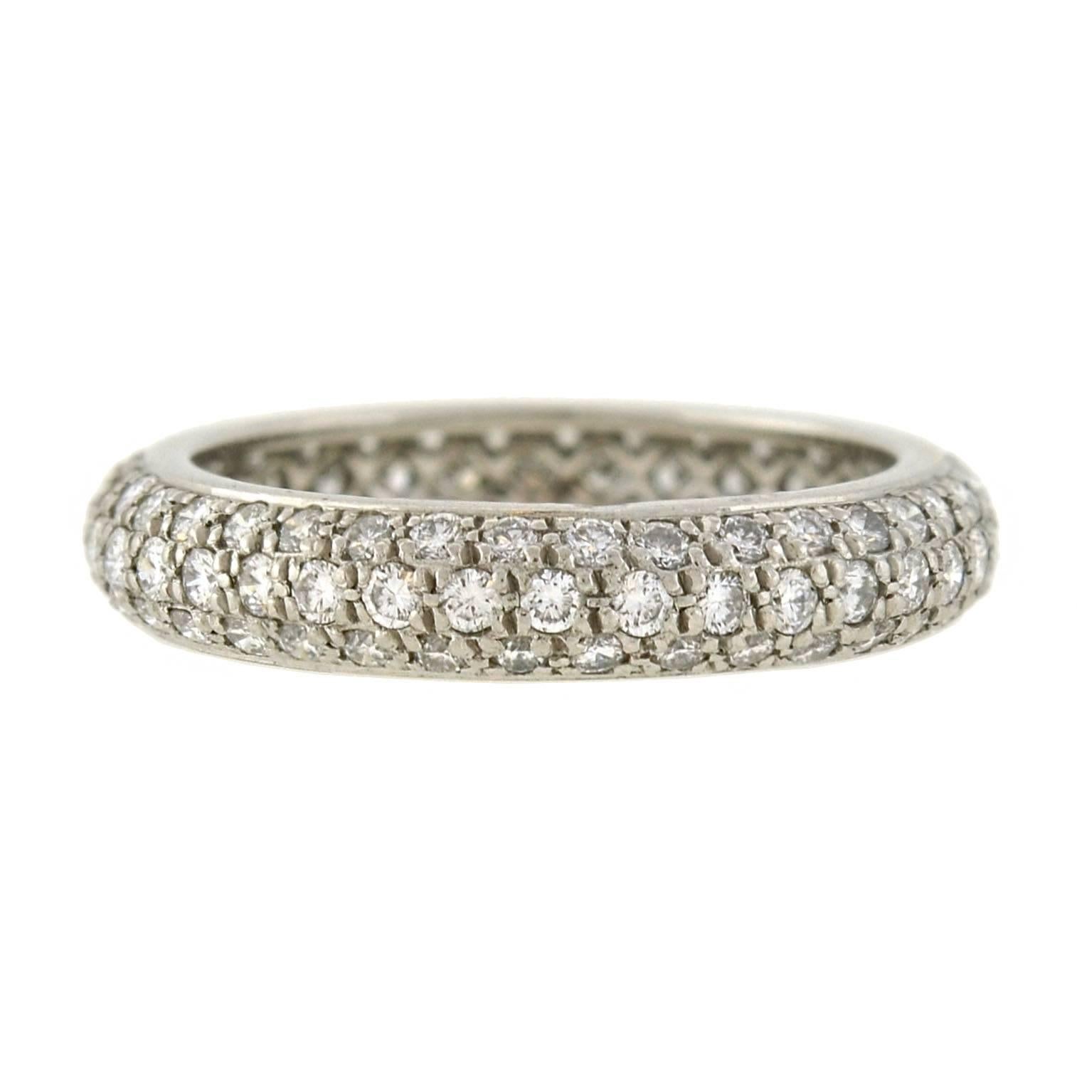 This stunning pavé diamond band is a signed estate piece by Cartier! Crafted in platinum, the ring boasts a spectacular diamond encrusted surface, which carries seamlessly all the way around the exterior. Collectively, the diamonds weigh