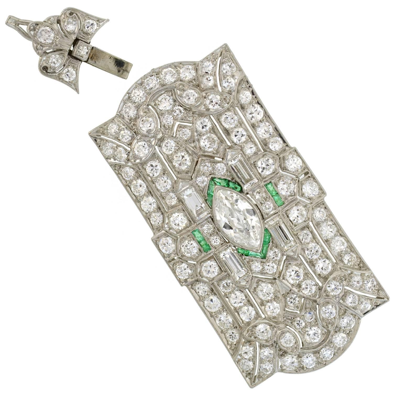 A spectacular diamond and emerald pin/pendant from the Art Deco (ca1920) era! This stunning piece is made of platinum and particularly large in size and can easily be worn as a pin or pendant. Depicting an incredible Deco design, the pin/pendant has