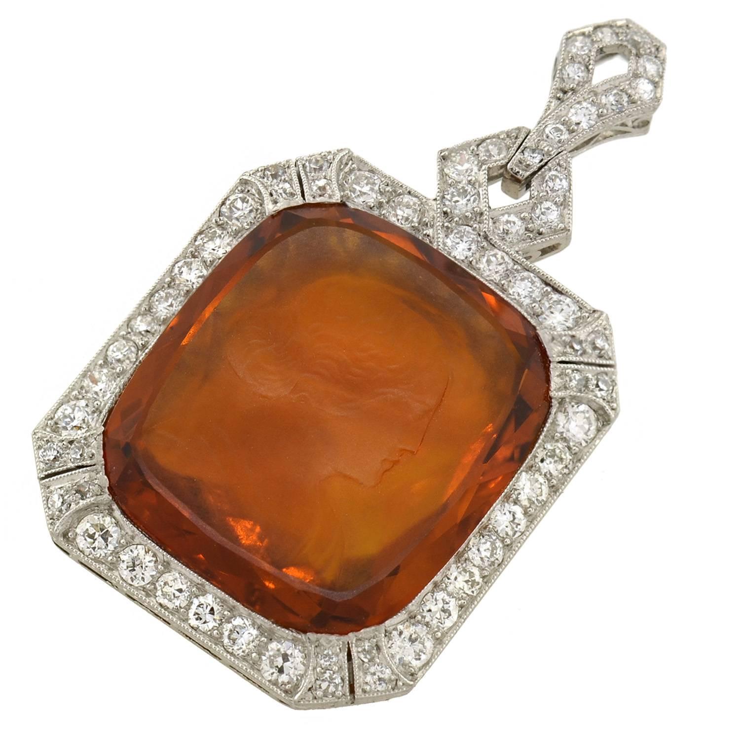 A stunning carved citrine cameo pendant from the Art Deco (1920) era! This fantastic piece depicts a large, rectangular-shaped citrine stone which is surrounded by sparkling diamonds. The citrine, which is vibrant in color with hues of orange,