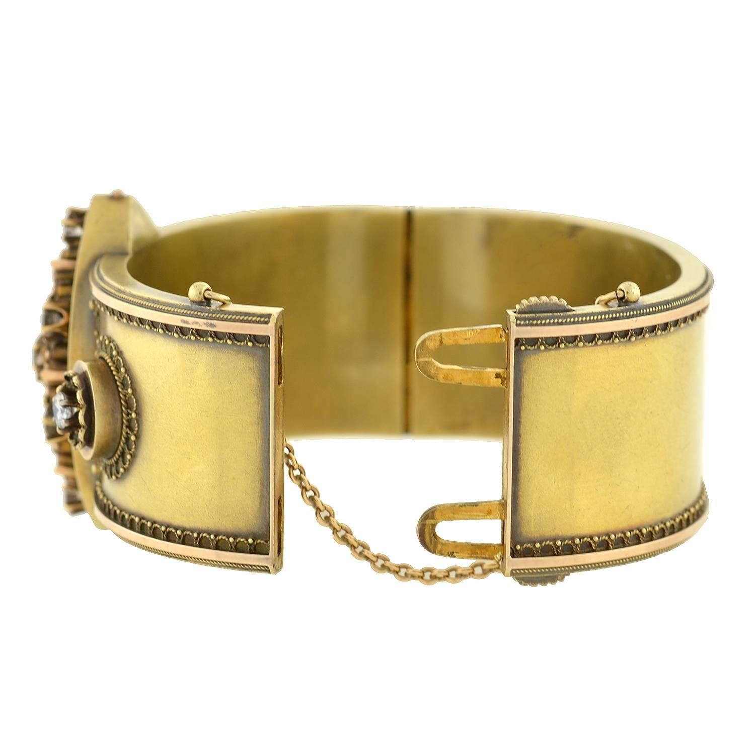 An absolutely exquisite gold bangle bracelet from the Victorian (ca1880) era! This wide bangle is made of vibrant 15kt yellow gold and has a fantastic 3-dimensional design on the front surface. At the center of the bangle is an oval shaped plaque