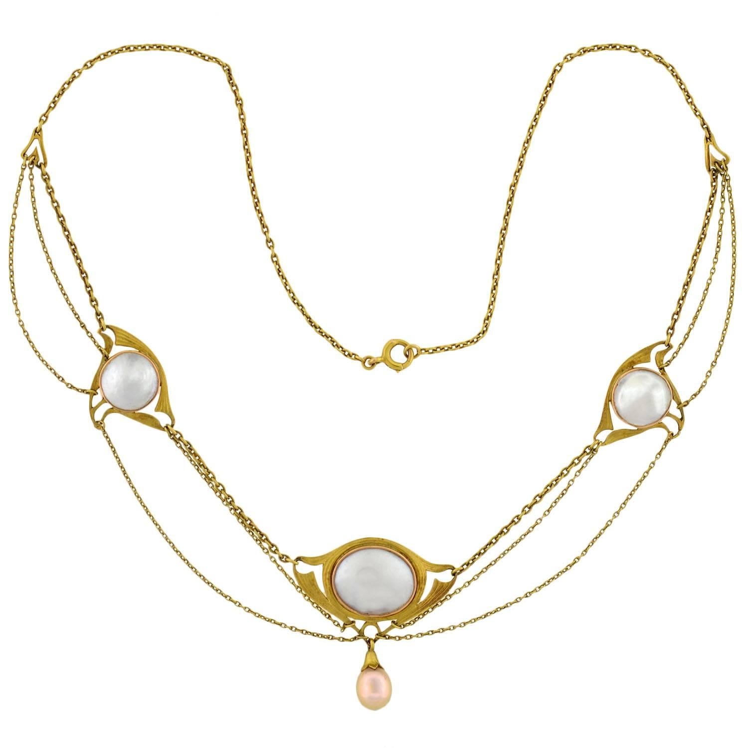 An exquisite blister pearl necklace from the Art Nouveau (ca1910) era! This unique necklace, which is made of 18kt yellow gold, holds three ornate links with the largest in the middle. Each holds a lovely blister pearl at its center, which is framed