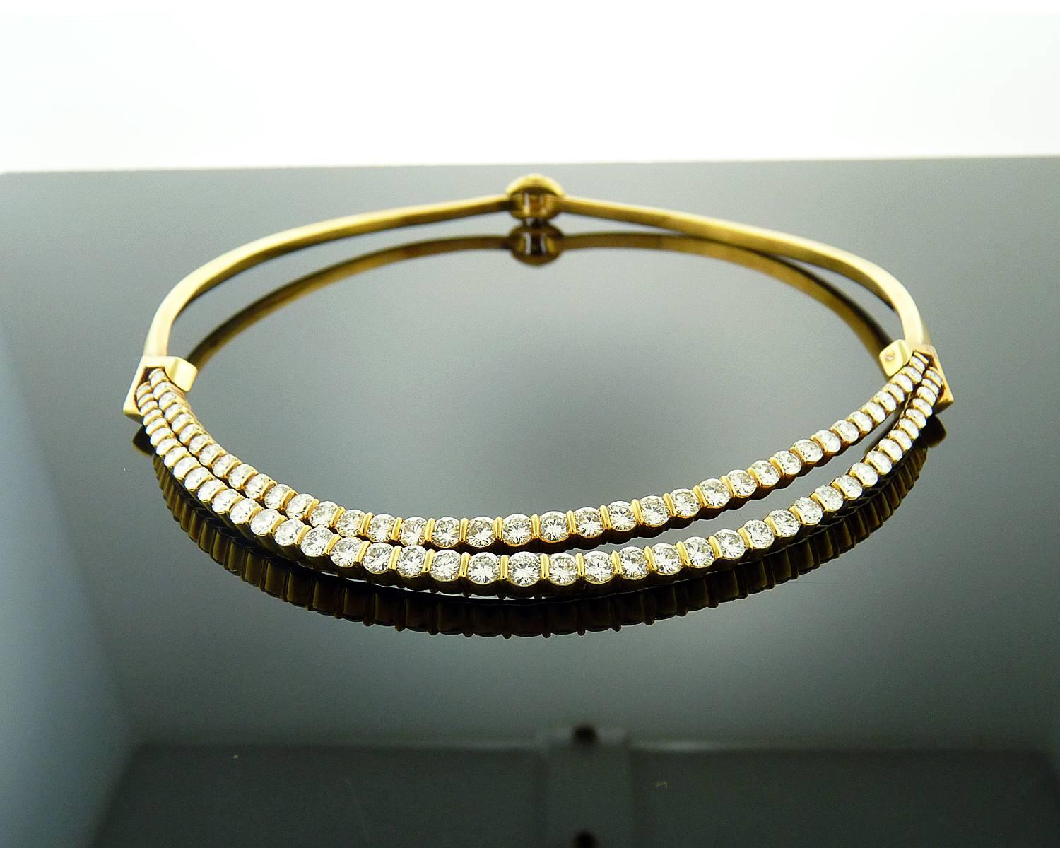 This stunning piece is finely crafted in 18K yellow gold and has a collar-length design. 
The necklace is composed of 82 Round Brilliant Cut Diamonds weighing approximately 10.00 carats and has two rows of bar-set graduated diamonds.
The largest,