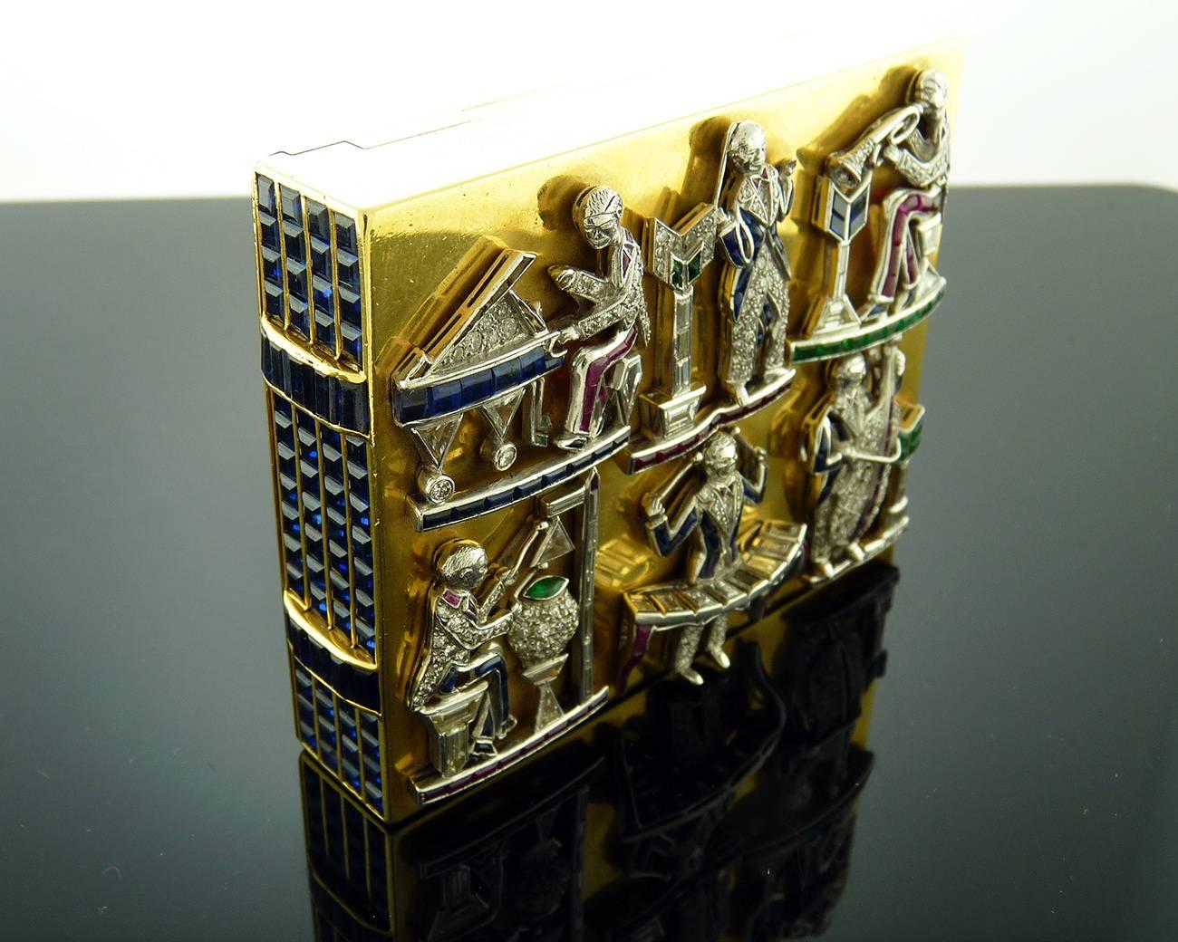 Of rectangular shape, the hinged cover set with diamond and multi-gem charms of various American patriotic motifs, the reverse set with diamond and multi-gem charms of various musicians, to the sides set with calibré-cut sapphires, opening to