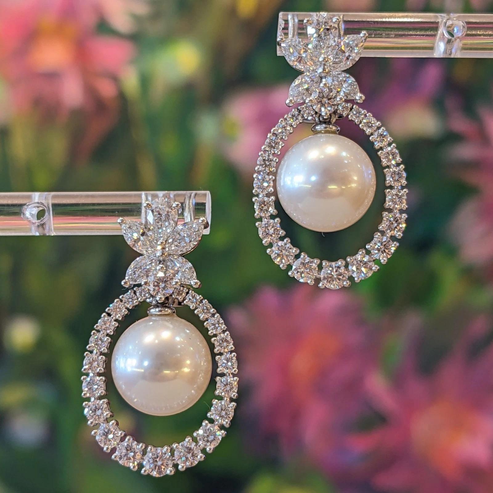 Orecchini pendenti con diamanti naturali e perle in oro bianco 18 carati 

Gli orecchini con diamanti e perle sono caratterizzati da diamanti a forma di pera, marquise e tondi brillanti incastonati a grappolo sopra e intorno a una perla bianca dei
