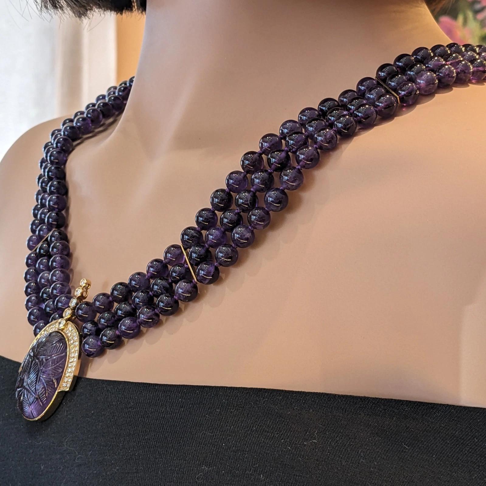 Collana con ciondolo in ametista e diamanti intagliati in oro giallo 18 carati 

La collana con ciondolo di ametista presenta tre fili di perline rotonde di ametista da 8 mm con un ciondolo di ametista intagliato con motivo a foglia circondato da un