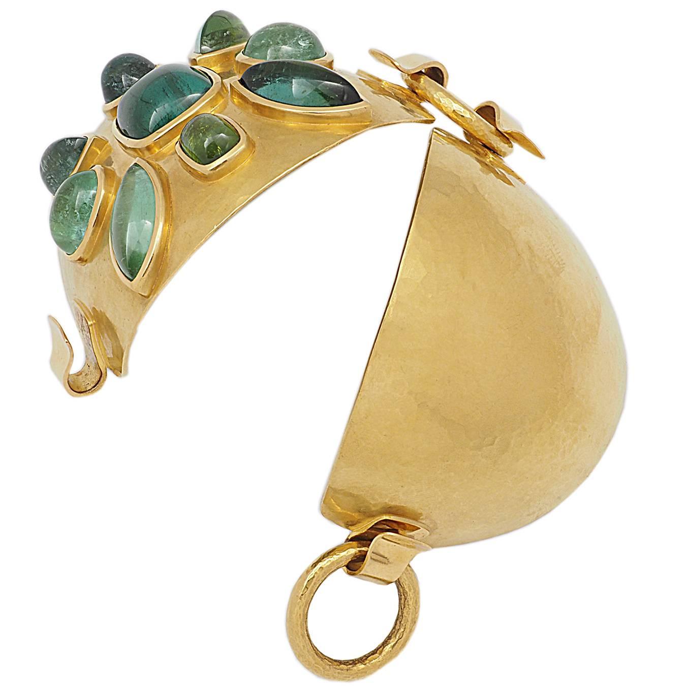 Colleen B. Rosenblat designed this marvellous bracelet.
22k hammered yellow gold encase this 9 beautiful green tourmalines cabochons 77.42 ct arranged as a flower.
This is definitely an eye-catcher for everyone!
length: 18 cm
width: 55 mm
