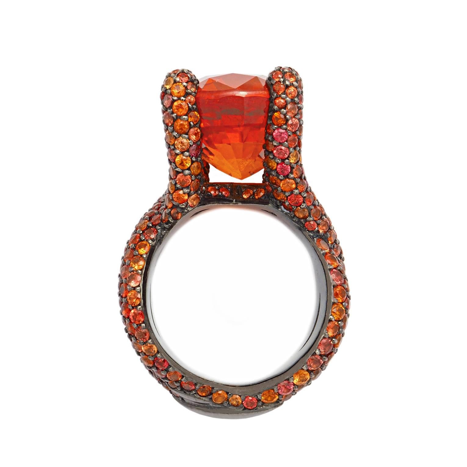 This spectacular Cocktail ring, is set in 18k blackened white gold paved with 412 intense orange Sapphires 9.1 ct and a magnificiant mandarine garnet 26.0 ct in the front. It is designed by Colleen B. Rosenblat. 