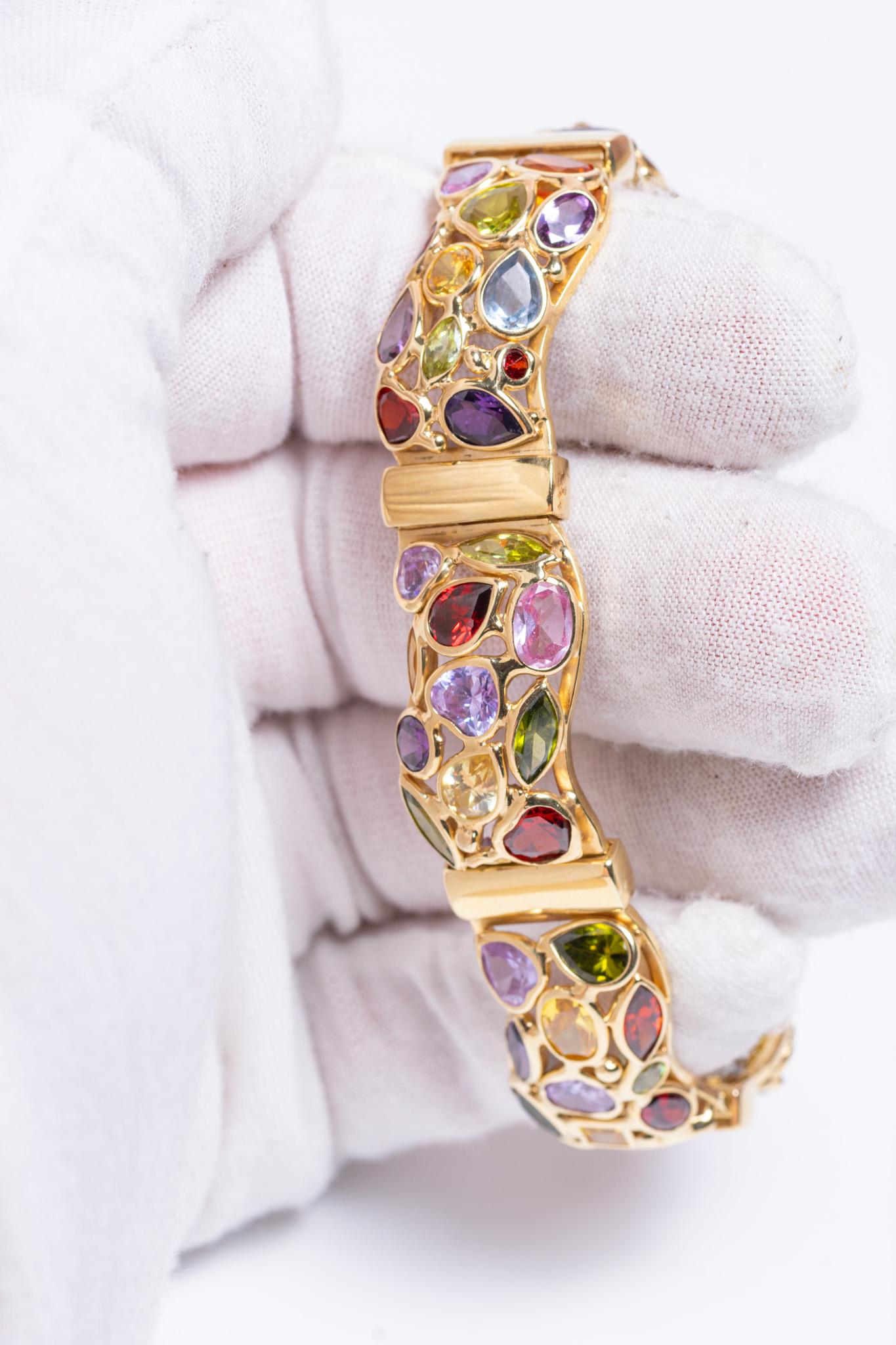Questo eccezionale vintage italiano  Il bracciale è realizzato a mano in oro giallo massiccio da 14 carati e incastonato con una straordinaria serie di gemme naturali multicolori. Ogni gemma è stata selezionata con cura e incastonata con maestria