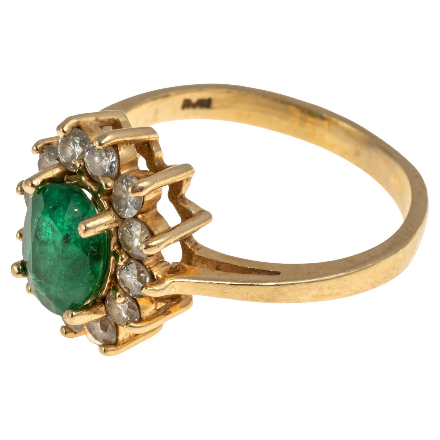 Bague cocktail 14KG avec émeraudes et diamants
Superbe bague vintage en or jaune 14k, style Princesse Di, avec émeraude vert foncé et diamants.  Monture avec un centre ovale d'émeraude verte facettée d'environ 1,25 carats. Entouré d'un halo de 12