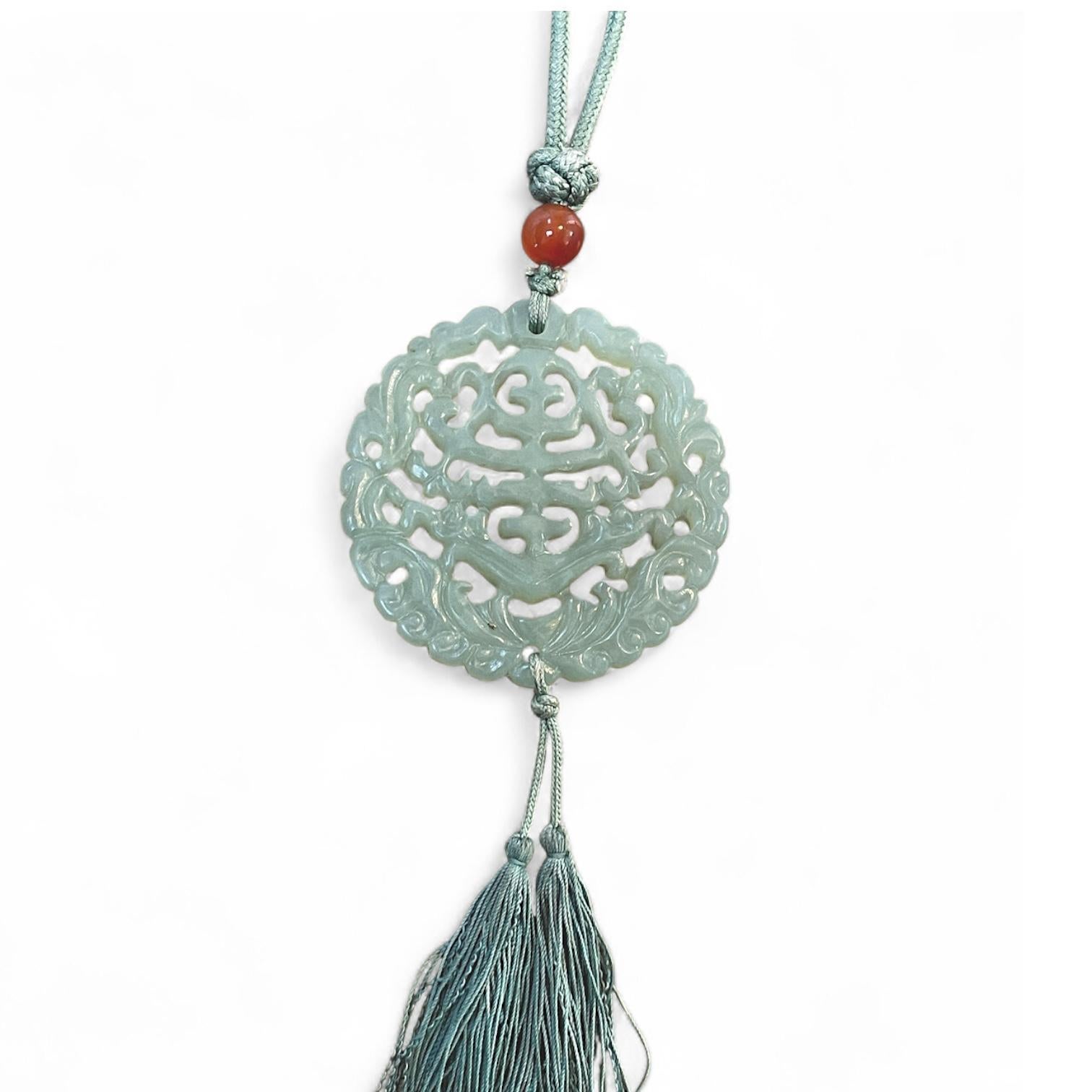 Rehaussez votre collection d'accessoires avec cet exquis collier Antiques, doté d'un superbe pendentif en jade vert orné d'un délicat pompon et d'un charmant motif floral. Mesurant 26 pouces de long, le collier est fabriqué à partir d'un cordon