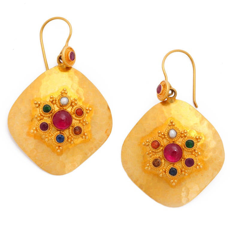 A pair of 18kt yellow gold cushion shape earrings. The earrings have bezel set rubies, emeralds, coral, pearls, citrine, sapphires and garnets. The stone bezels are decorated with gold rope and bead work.