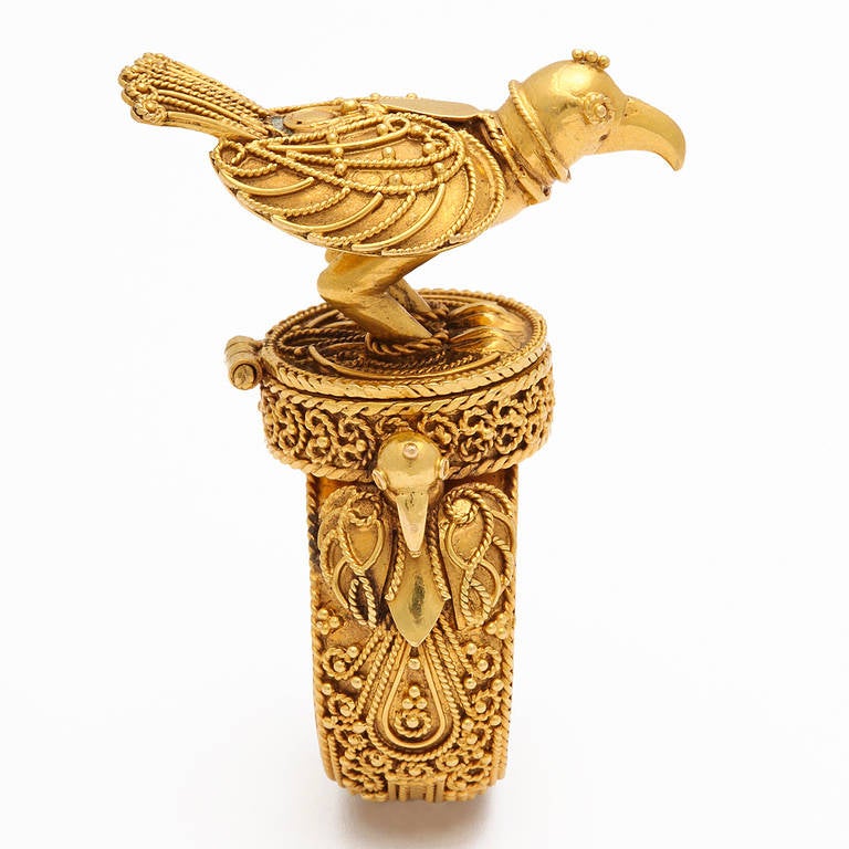 An 18kt yellow gold hand crafted Bird ring. The ring opens to reveal a secret compartment. There are moveable chains around the bird's feet so it can't fly away. Size 8