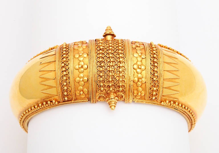 An 18kt yellow gold contemporary temple style bracelet. The bracelet is adorned with flowers, leaves and beaded vine work.
Width: 3.25 x 3.00 inches
interior diameter: 2.50 inches