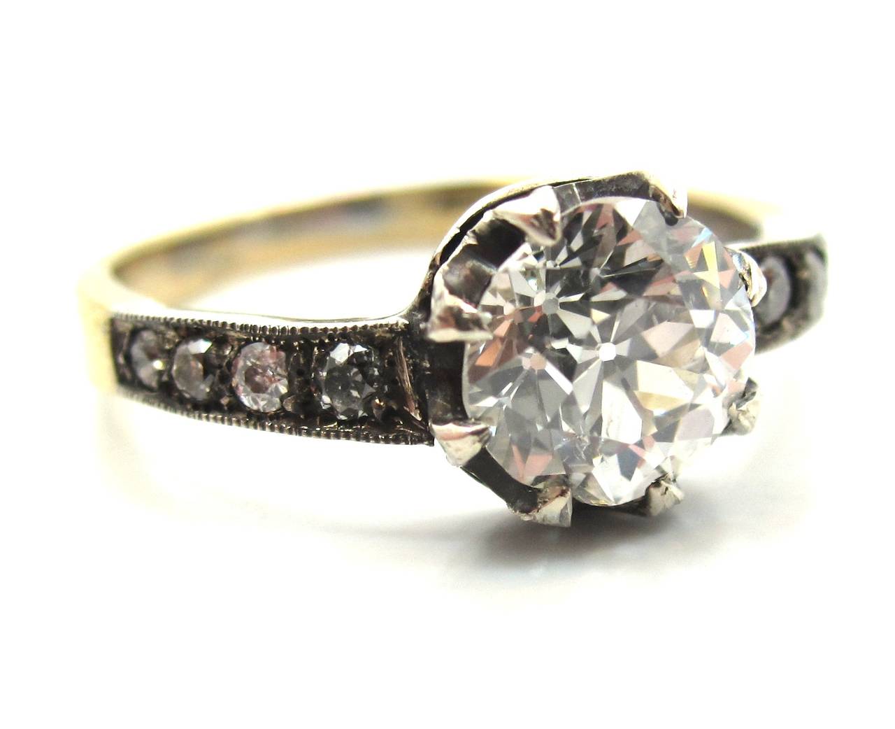 A rare example of an early French Edwardian (circa 1905) mixed metal engagement ring.
Handcrafted in 18 karat yellow gold with a silver top. Featuring a center stone 1.25 Carat Old European Cut diamond. Delicately claw prong set in a 