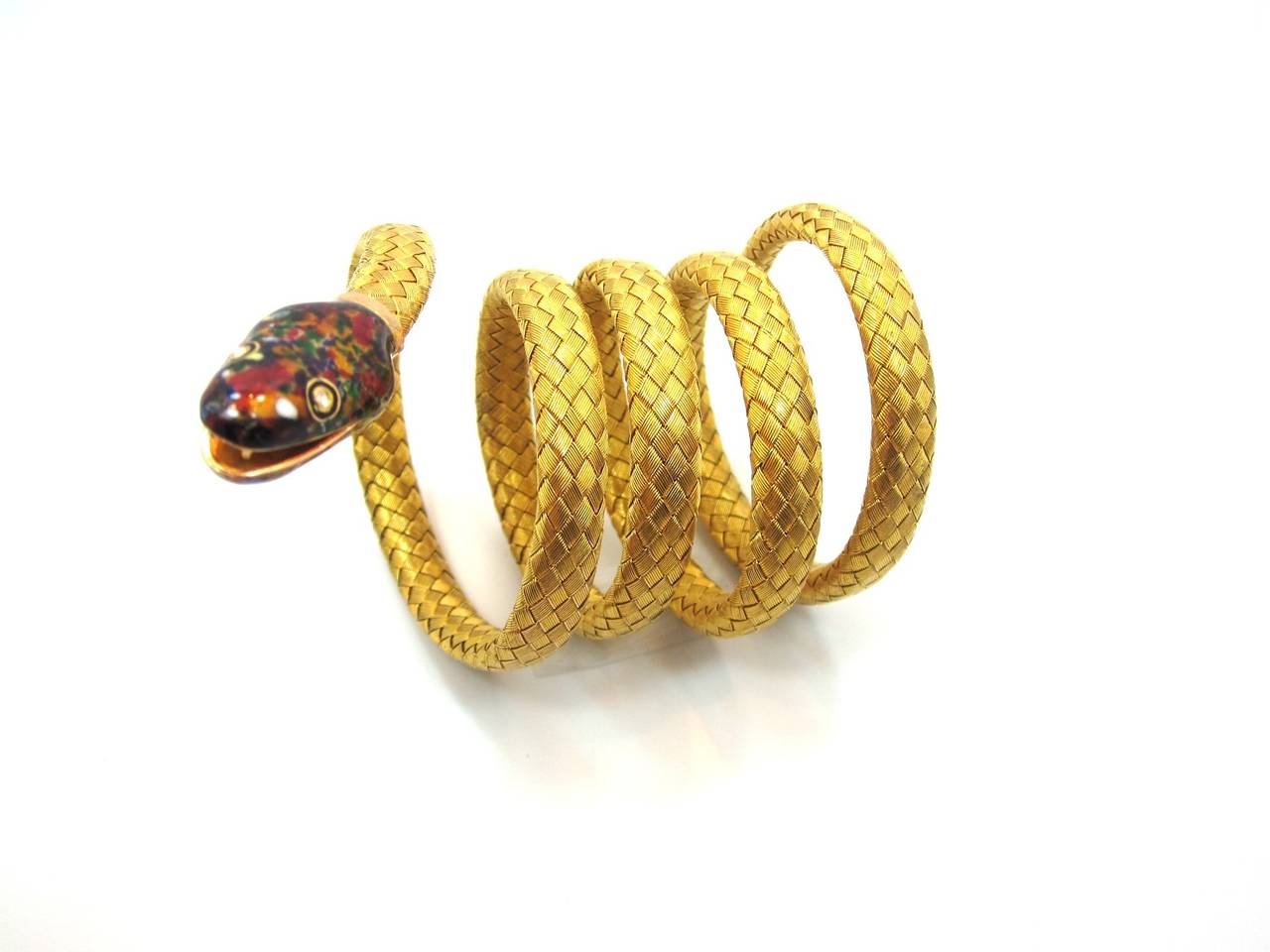 Superb example of Victorian craftsmanship. Handcrafted in a 18 karat yellow woven design. The coiled snake is flexible allowing you to wrap the bracelet around your wrist. The snake head is beautifully decorated with multi colored enamel and the