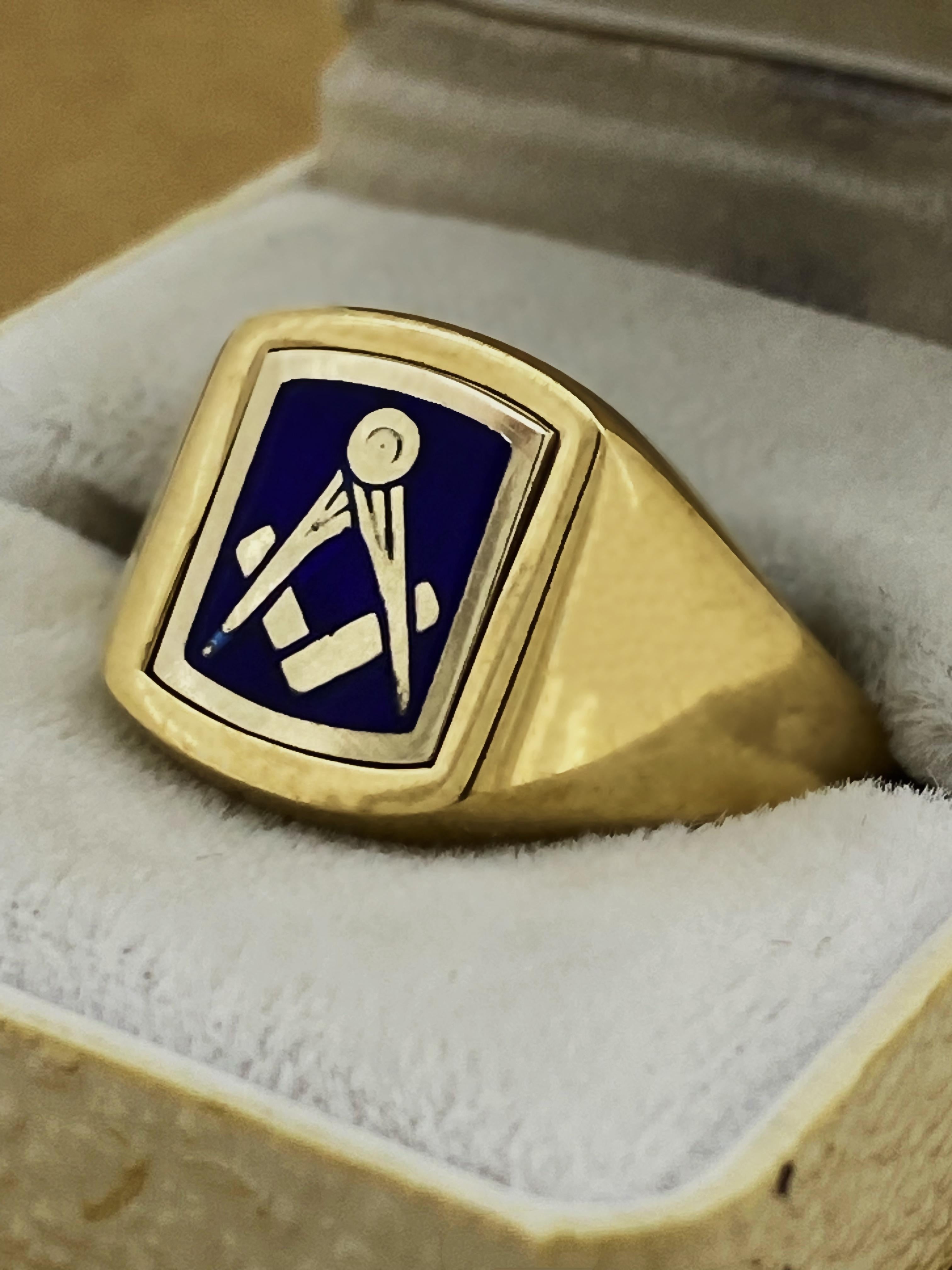 Di un design desiderabile per il sigillo, 
questo solido e pesante anello da uomo in stile Art-Deco
è meticolosamente realizzato in oro giallo 9 carati.

Il pannello frontale è in smalto blu e presenta  
il simbolo massone del quadrato e del