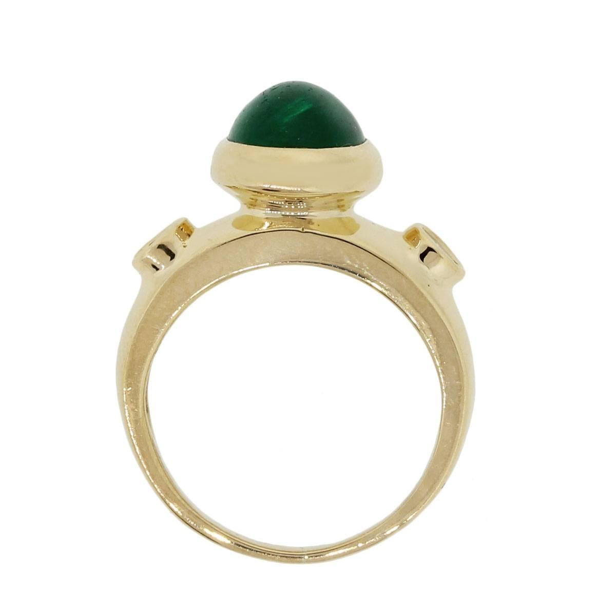 Material: 18k yellow gold
Diamond Details: Approximately 0.20ctw round brilliant diamonds. Diamonds are G/H in color and VS in clarity
Gemstone Details: Oval cabochon green emerald measuring approximately  9.75mm x 7.69mm
Ring Measurements: 1″ x
