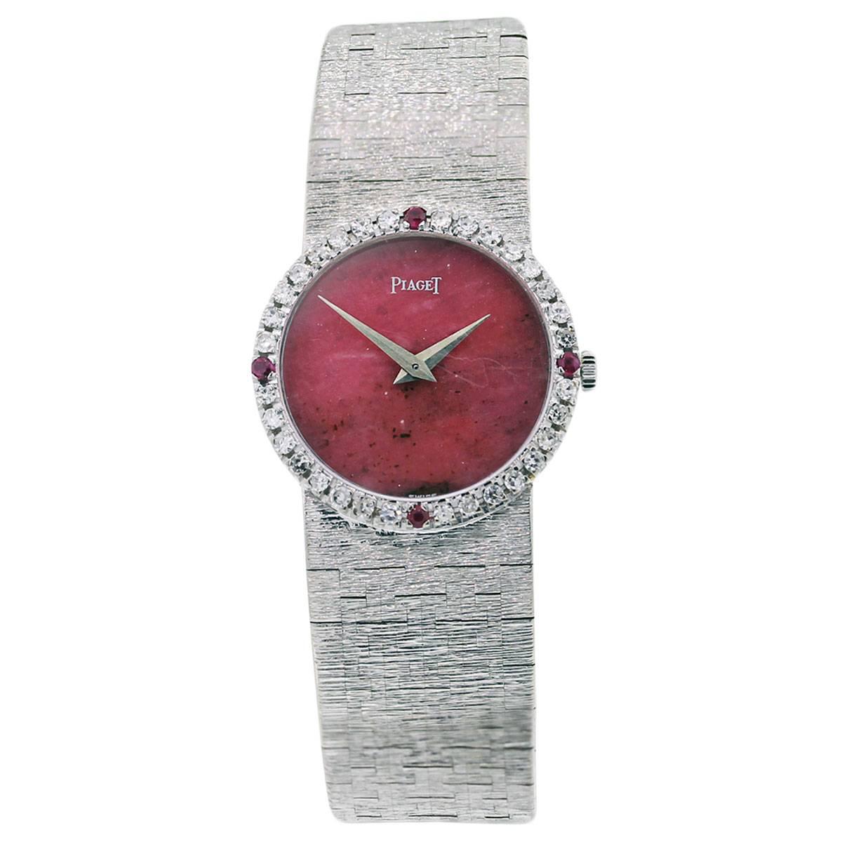 Brand: Piaget
Style	: 18k White Gold Ruby Red Hardstone Dial with Diamond & Ruby Bezel Watch
MPN: 9706 A 6
Case Material	18k White Gold
Case Diameter: 24mm
Bezel:18k White Gold and Factory Diamond & Ruby Bezel
Diamond Details: Diamonds are G