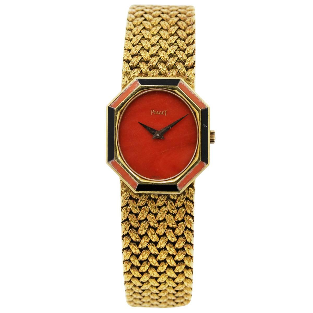 Brand: Piaget
MPN: P341D2
Case Material : 18k Yellow Gold
Dial 	Coral Stone
Bezel: Coral & Onyx Stone Octagon Shaped Bezel
Case Measurements: 26.5mm x 23.5mm
Bracelet: 18k Yellow Gold Braided Rope Bracelet
Clasp: Piaget Jewelers Clasp
Movement: Hand