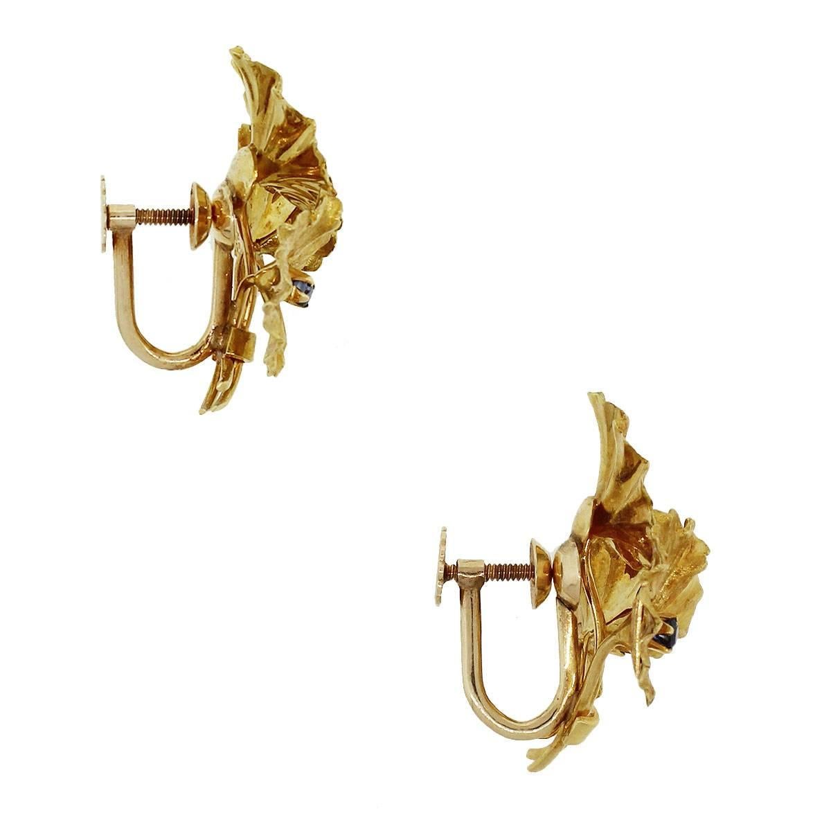 Tiffany & Co. Blumenohrringe mit ca. 0,03 ctw Saphir. Metall ist 18k Gelbgold. Die Abmessungen sind 1,06″ x 0,90″ x 1,18″ Gesamtgewicht ist 12,4g (7,9dwt). Kommt mit original Tiffany & Co. Etui. SKU G7076