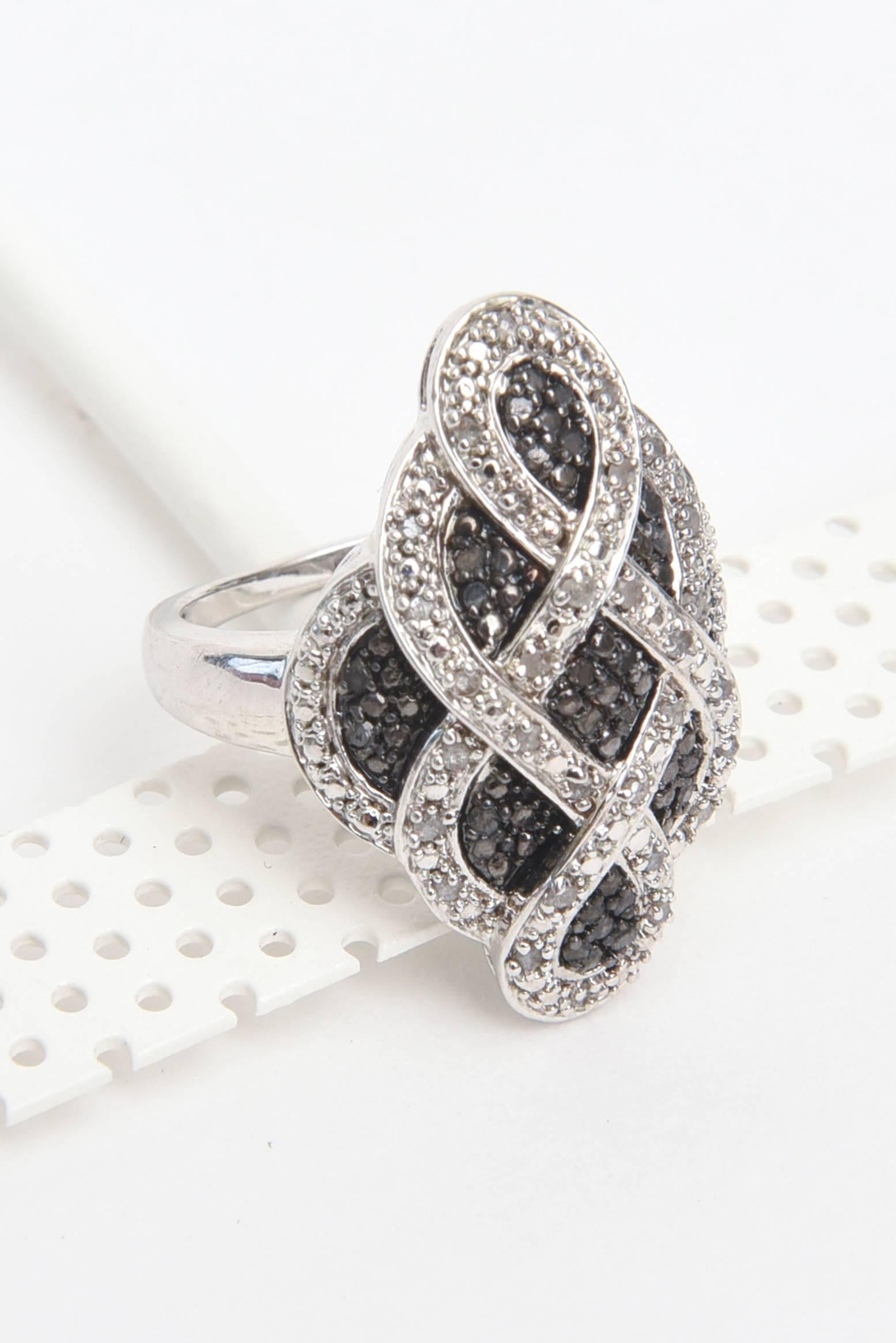 This lovely criss cross contemporary diamond ring is set in sterling silver. It is a combination of lower grade commercial combination of white and black diamonds. The total carat is about 1 carat total in the combination of both kinds of