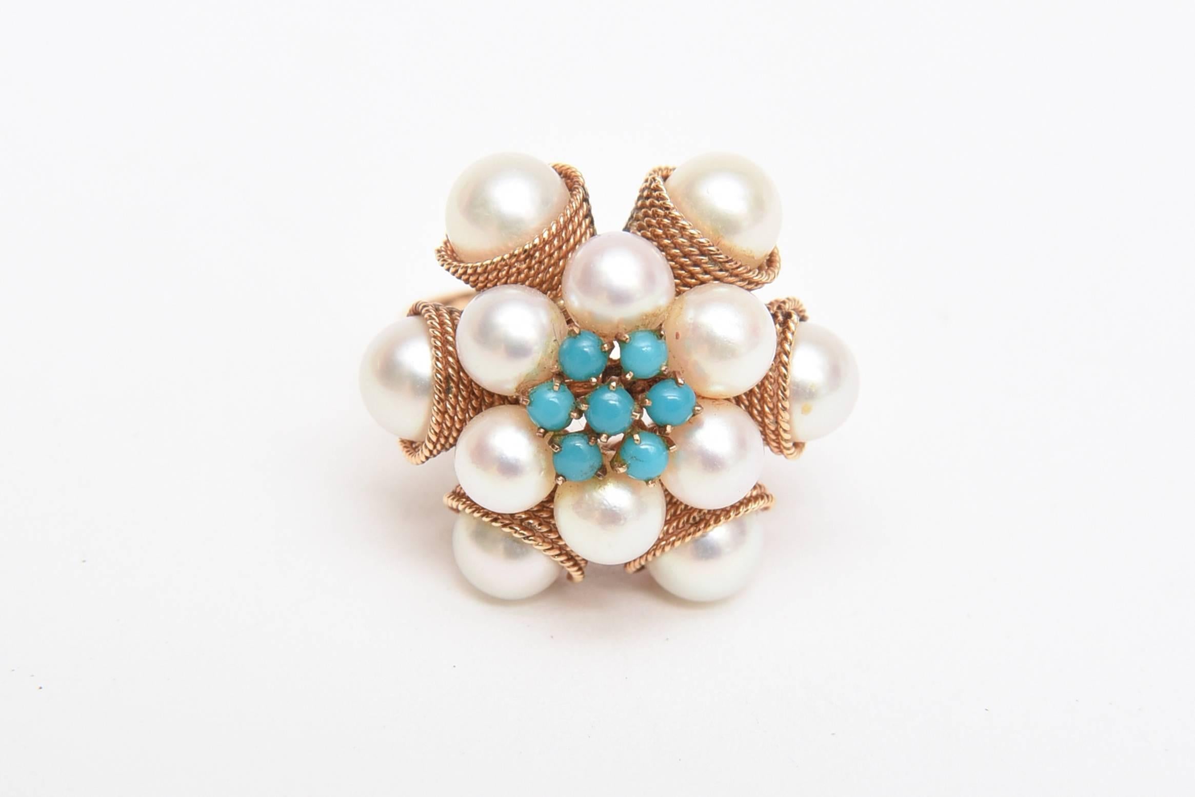 This lovely and elegant 14K dome vintage cocktail ring consists of 12 cultured pearls and 7 turquoise cabochon stones that are prong set. The larger pearls are encased in a beautiful line banded setting of 14 K yellow gold and the other pearls are
