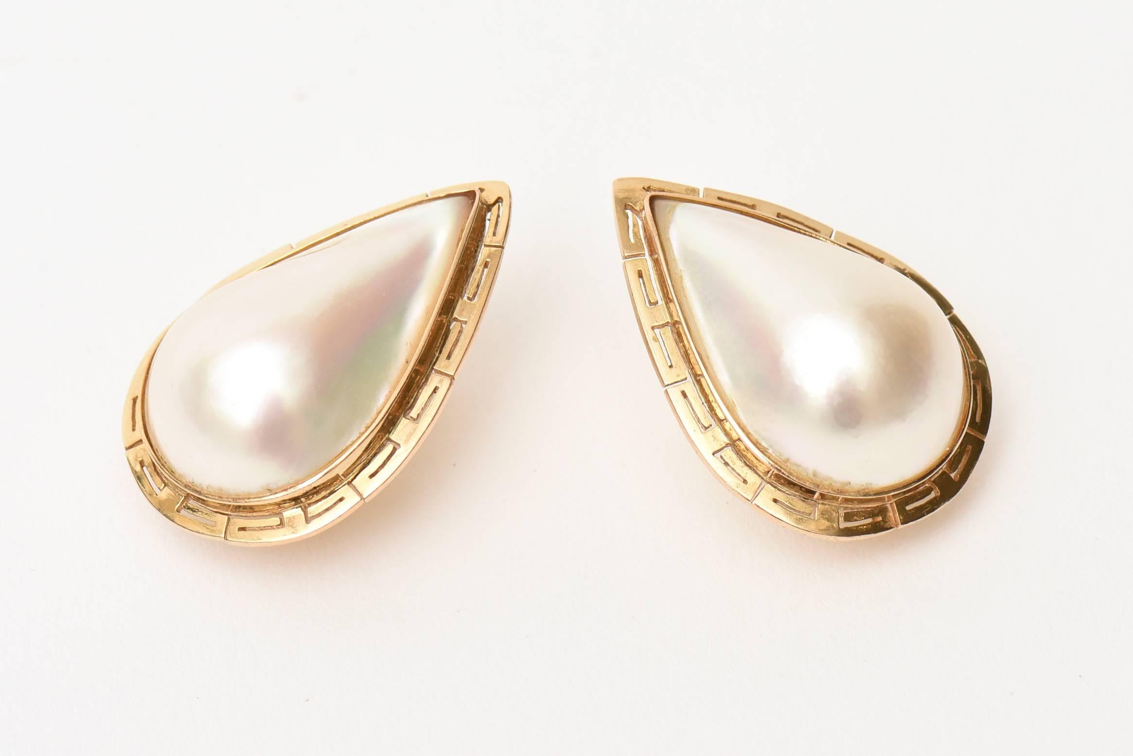 These gorgeous and vintage substantial sized teardrop shaped Mabe Pearl and 14 Karat Gold pierced earrings are classic and stunning. They are large Mabe pearl surrounded with a 14K yellow gold band that resembles a rendition of a semi greek key