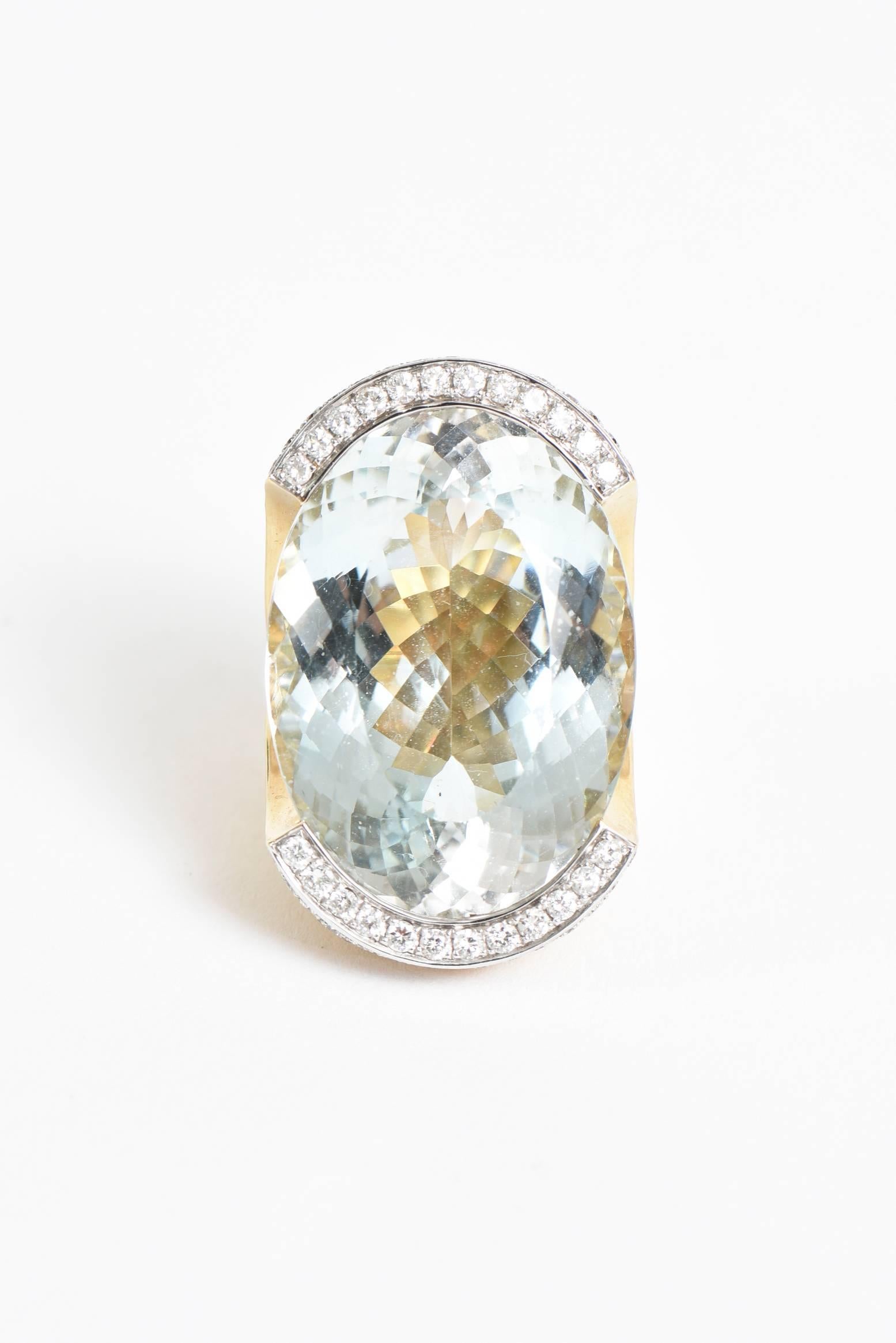 This custom made stellar monumental cocktail ring that is a brilliant aquamarine of a light blue color, !8K Satin Gold and Diamonds has great presence.. The aquamarine is  approx. 78.6 in carats that is mounted in a heavy made modernist 18K gold