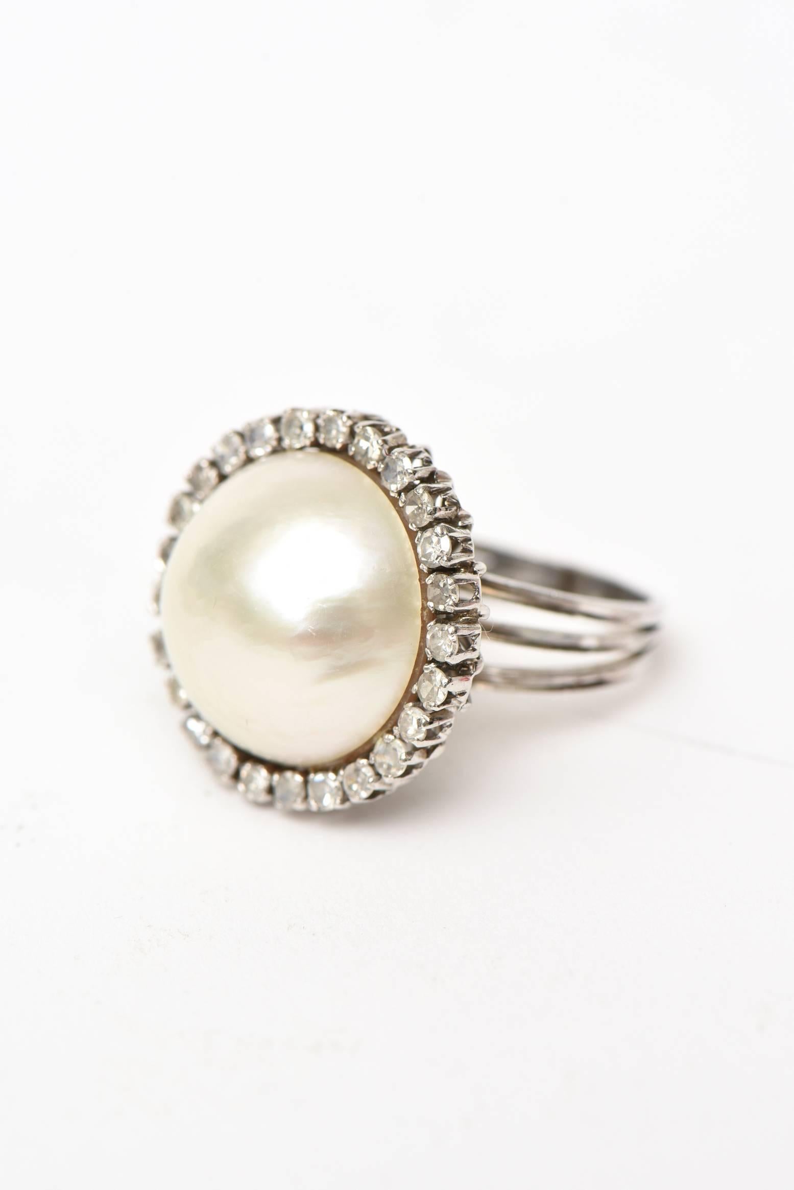 This 60's lovely vintage dome cocktail ring has a mabe pearl surrounded by 26 round diamonds. it is 14 K white gold. It has approximately one carat of diamonds surrounding the mabe pearl. The beautiful cage like design on the back is in 14 Karat
