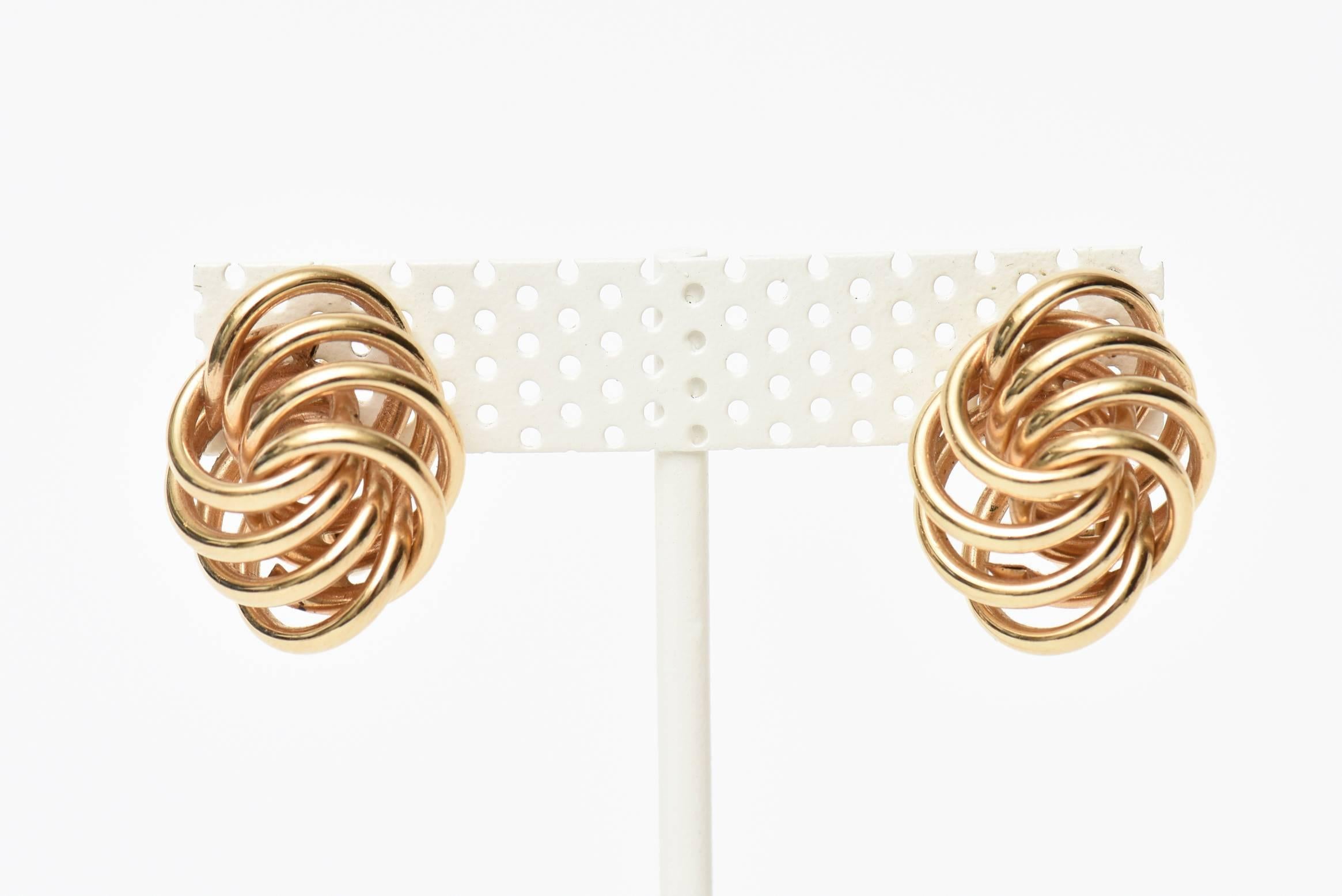 These lovely vintage 14K gold earrings have both a sculptural form. The concentric circles overlapping of gold that are layered go in and out almost form a shape of a knot. On the ear lobe, they have dimension and jut out to the side. Very