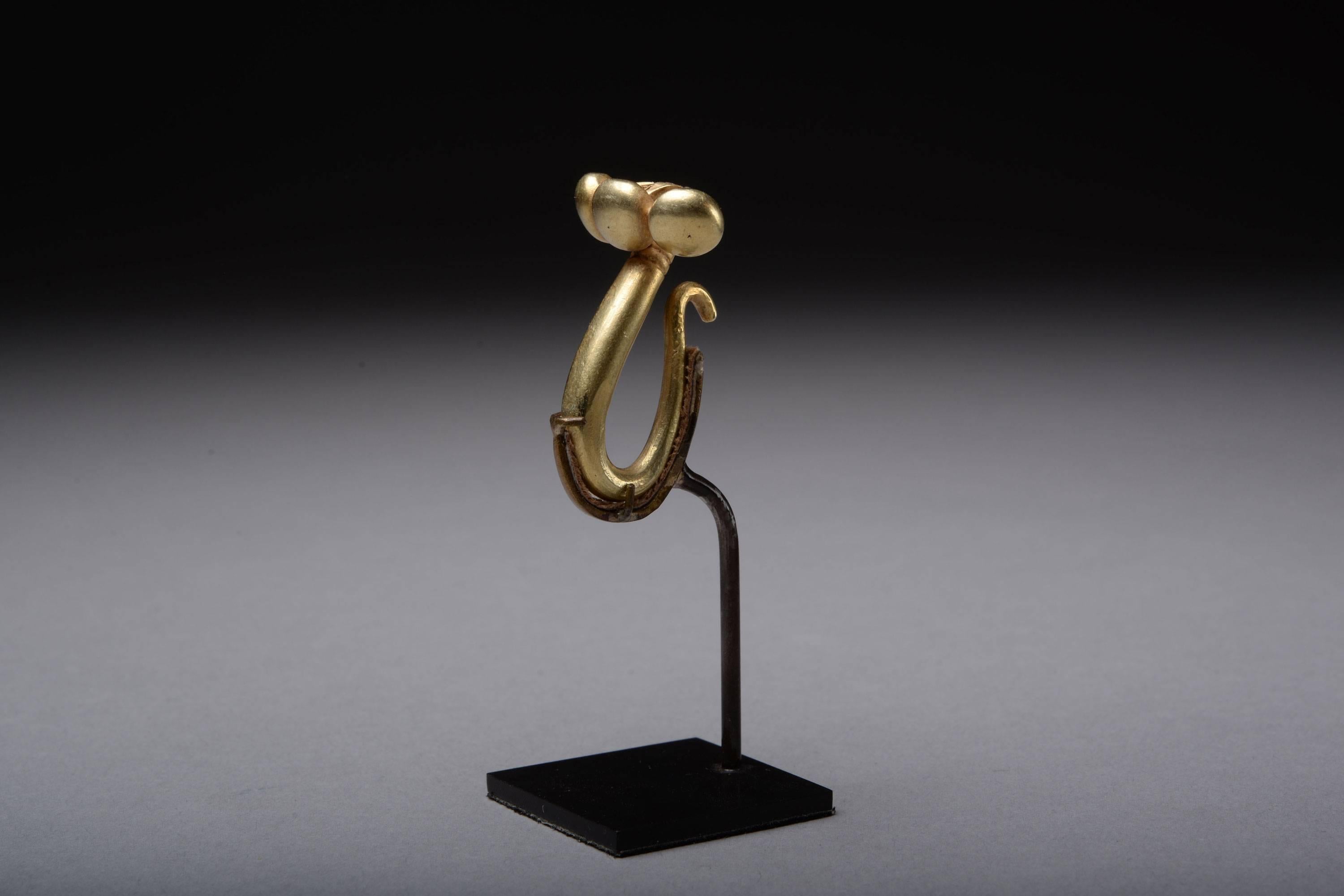 An ancient Greek solid gold dress fastener, dating to the 6th Century BC.

A most unusual brooch-like fastener, which likely functioned as a button in antiquity, drawing together two perforated pieces of fabric by means of the s-shaped loop at the