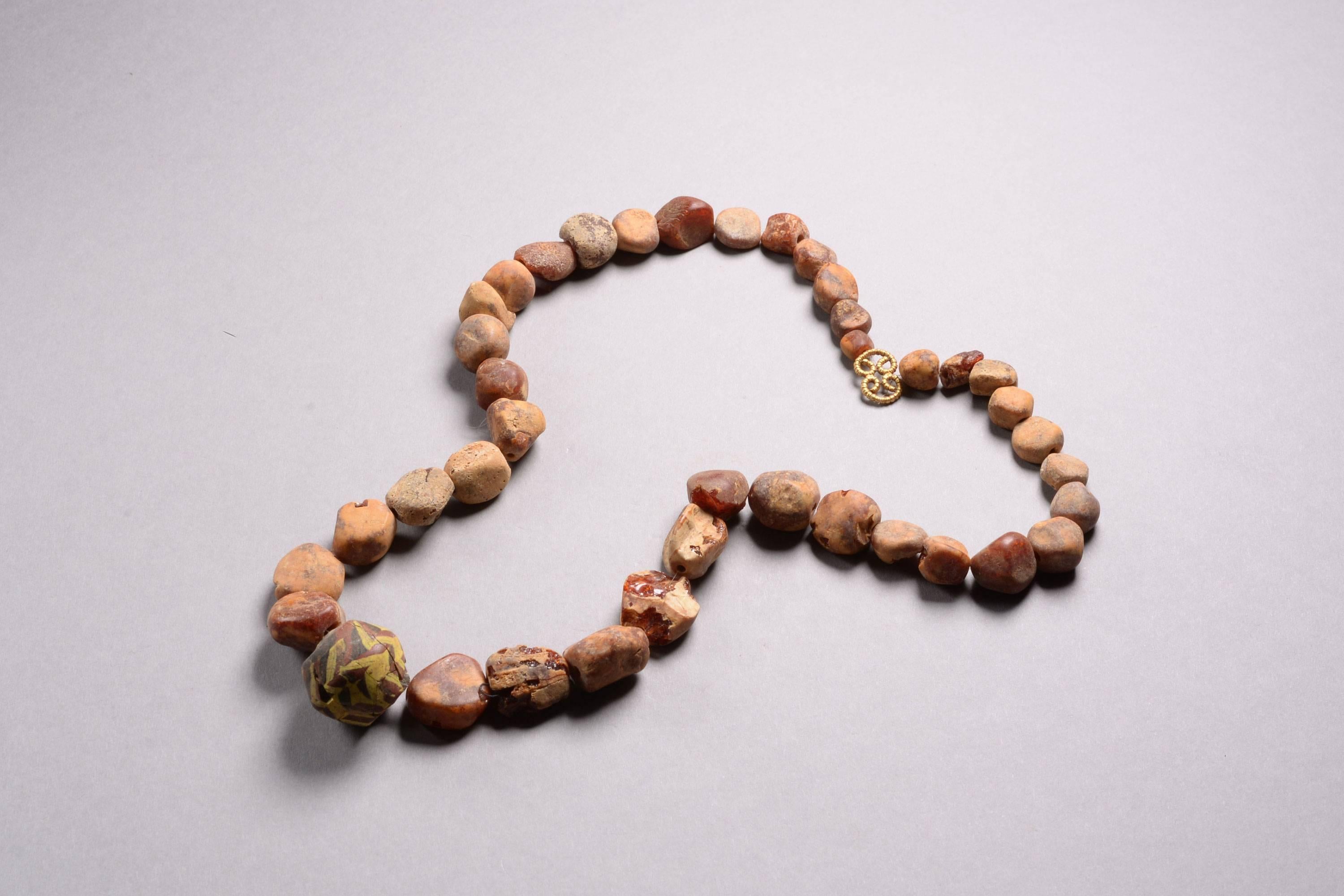 An Anglo-Saxon amber, gold and glass beaded necklace, dating to around 520 AD.

All the beads and clasp recovered from the same context and restrung with modern thread. The beads composed of beautiful amber, irregularly shaped, and a reticello