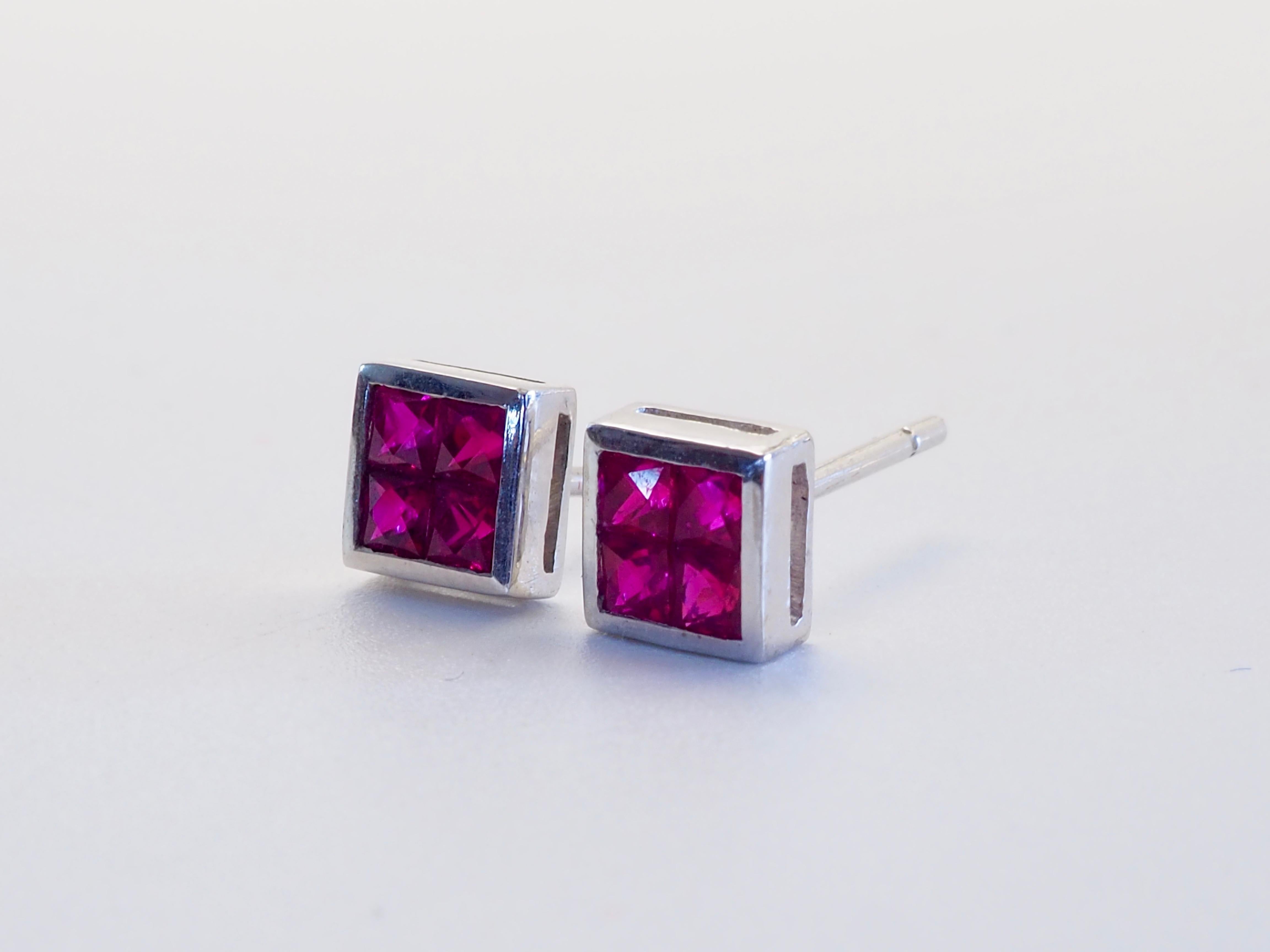 Magnifiques et uniques boucles d'oreilles réalisées dans les années 1990 et qui n'ont jamais été portées. Les boucles d'oreilles ont une forme géométrique unique avec un design en forme de canal. Il y a 8 rubis quadrillés et saturés de couleurs au