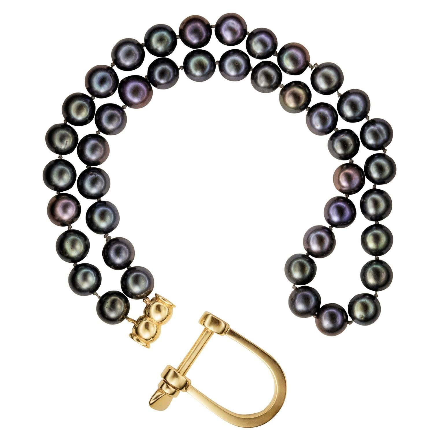 A double row of inky black Akoya pearls is clasped around the wrist with an unashamedly weighty 18K gold 'shackle' clasp. Subverting the preconceived ideas we hold of traditional pearls, this bracelet is not for the faint at heart. The sculpted