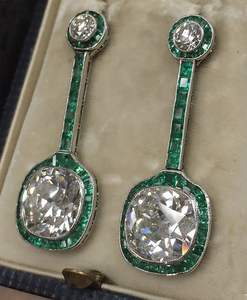 Exceptionally exquisite Art Deco diamond and emerald drop earrings, Circa 1925; Set in platinum the pair are set atop with two old European cut diamonds; total weight approximately 0.80  accented with French cut Colombian emerald halo. Total length