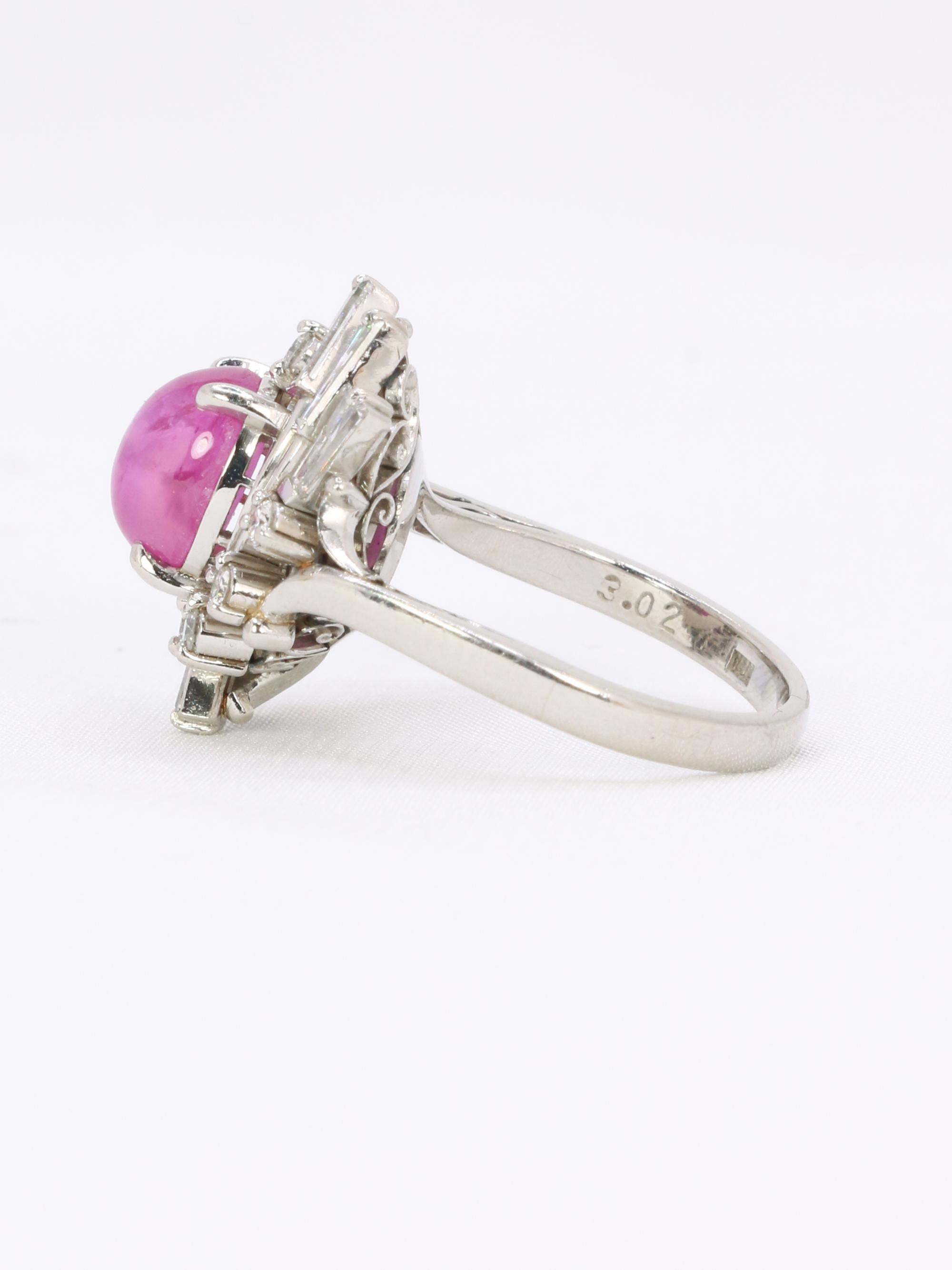 Star ruby and diamond platinum ring

Platinum ring set with a central star ruby weighing approximately 4.31 carats (8,52x6,84x5,42mm), fuchsia color (Pinkish red), of Burmese origin and showing no indications of heat treatment, in a stylized setting