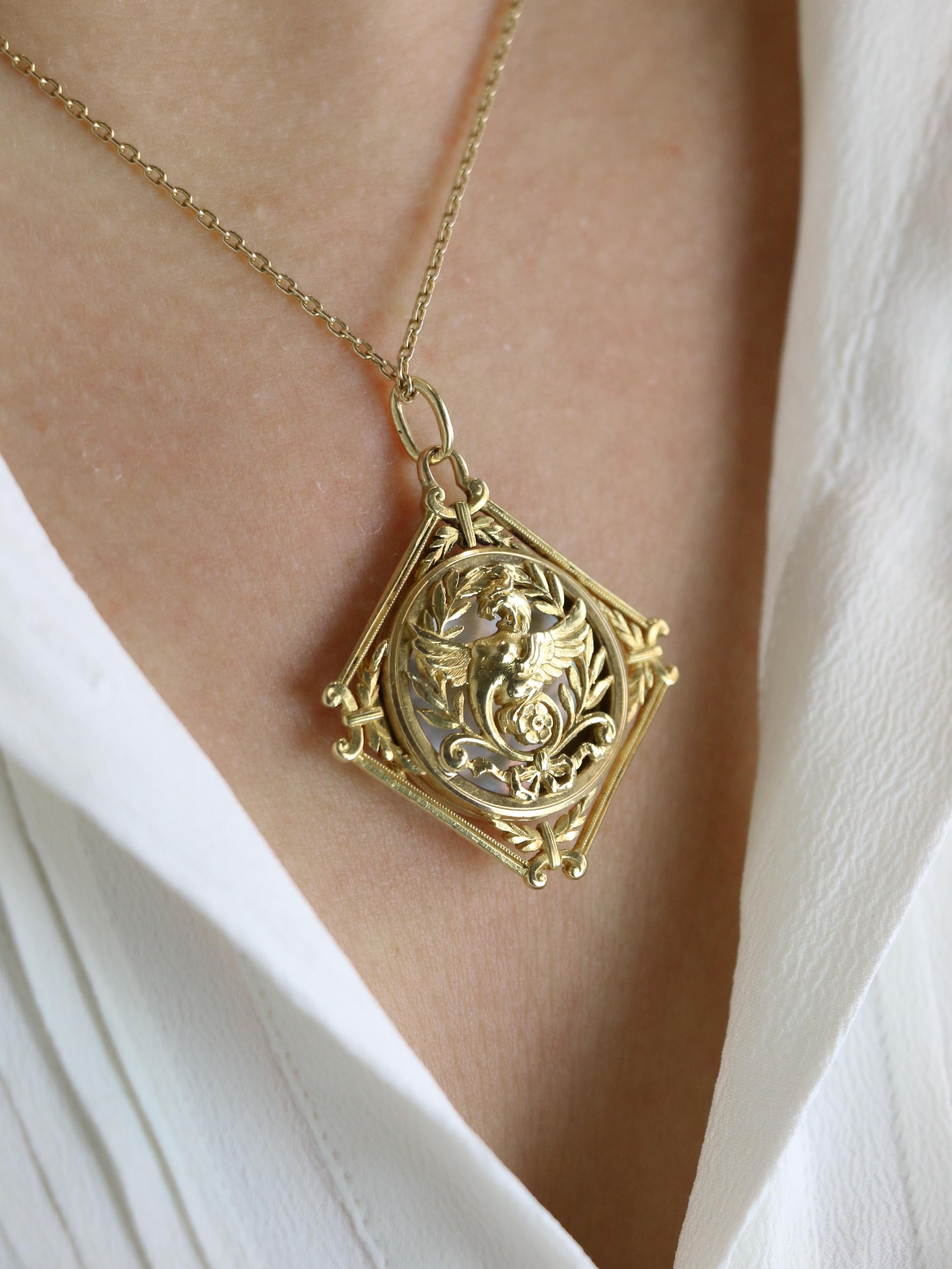 Pendente Art Nouveau a forma di chimera in oro giallo

Ciondolo medaglione neorinascimentale in oro 18k (750°/°°) con chimera in una decorazione floreale traforata. Il ciondolo si apre per rivelare una placca di madreperla. Sul retro, il ciondolo